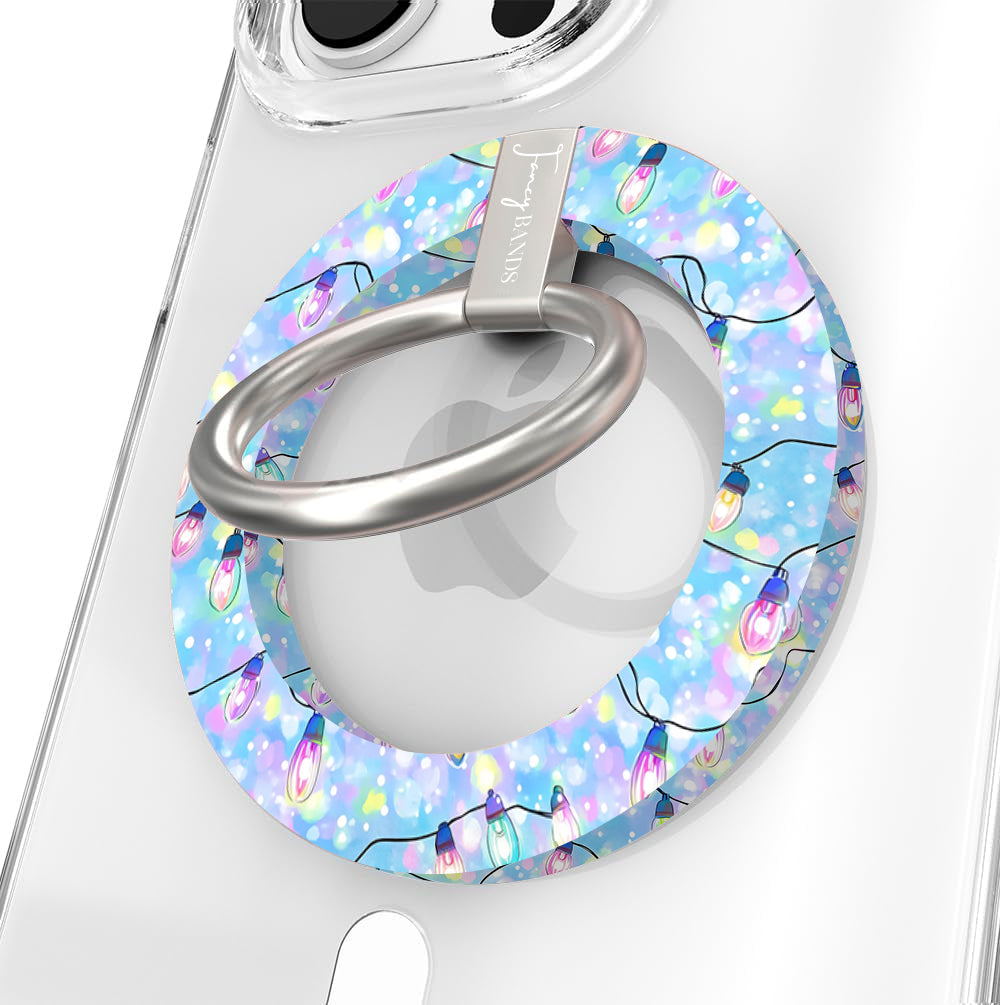 Close-up of the Twinkle All The Way MagSafe grip ring with pastel Christmas lights on blue and a brushed silver ring on a clear iPhone case