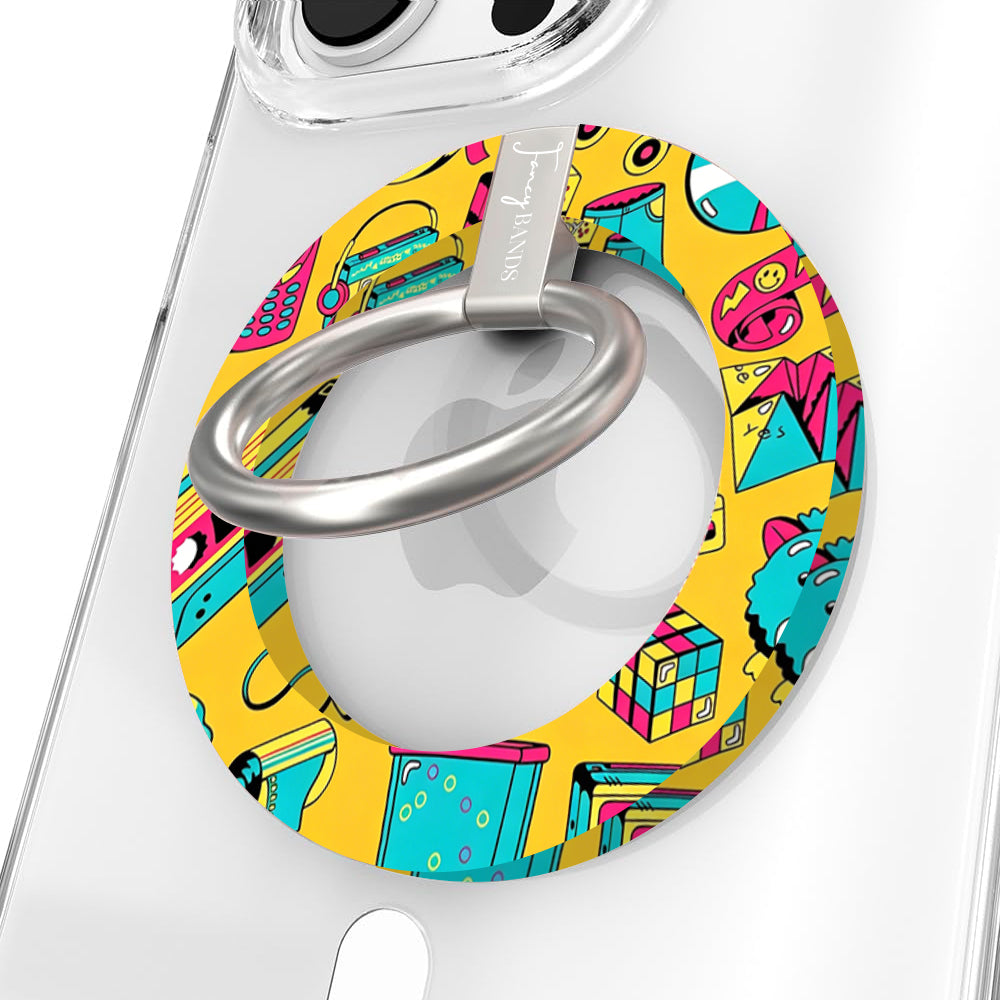 Oops It's the 90's retro pop art MagSafe phone grip ring with yellow background and colorful drawings of cassette players puzzle cubes and brick phones compatible with iPhone and Samsung