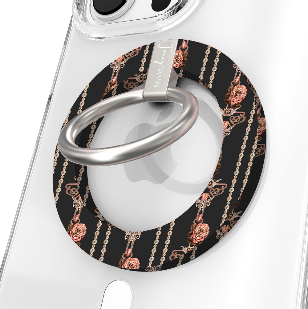 Pretty Little Details Hold It Fancy MagSafe grip ring in black with champagne pearl strands and rose gold rose drops, brushed silver ring, attached to a clear iPhone case.