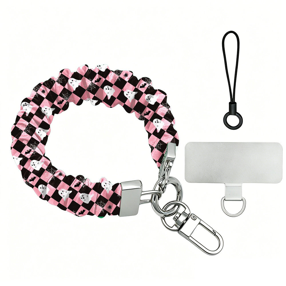 Hey Boo, Looking Cute Scrunchie Phone Wrist Strap shown with its metal clasp, black cord and phone attachment tab, pink and black checkerboard with white ghosts.