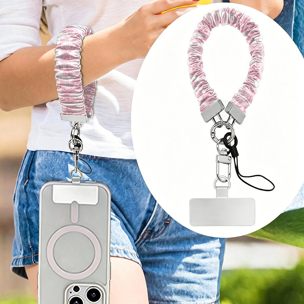 Blush Manor Scrunchie Phone Wrist Strap worn on the wrist with the phone at the hip, plus a close-up of the pink toile print and silver clasp.