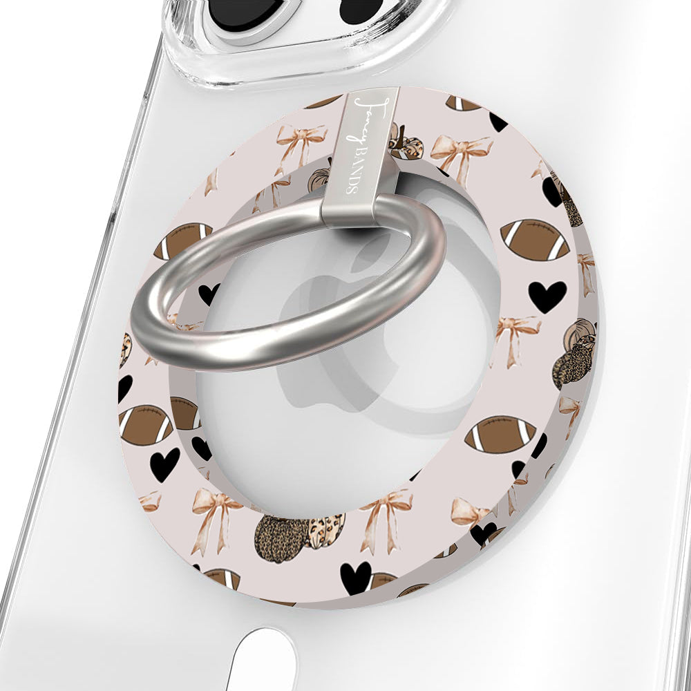 Game Day Darling Hold It Fancy MagSafe grip ring with a cream coquette print of footballs, leopard pumpkins, bows and hearts from Fancy Bands