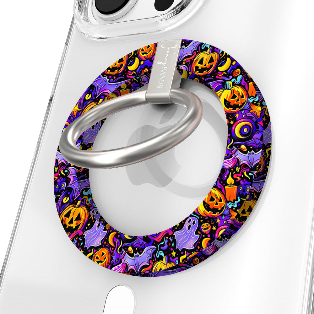 Jack-O-Lantern Jive Hold It Fancy MagSafe grip ring shown on a clear iPhone case, purple ring covered in glowing orange pumpkins and ghosts.