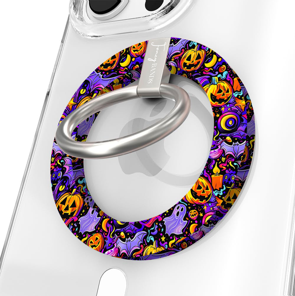 Jack-O-Lantern Jive Hold It Fancy MagSafe grip ring shown on a clear iPhone case, purple ring covered in glowing orange pumpkins and ghosts.