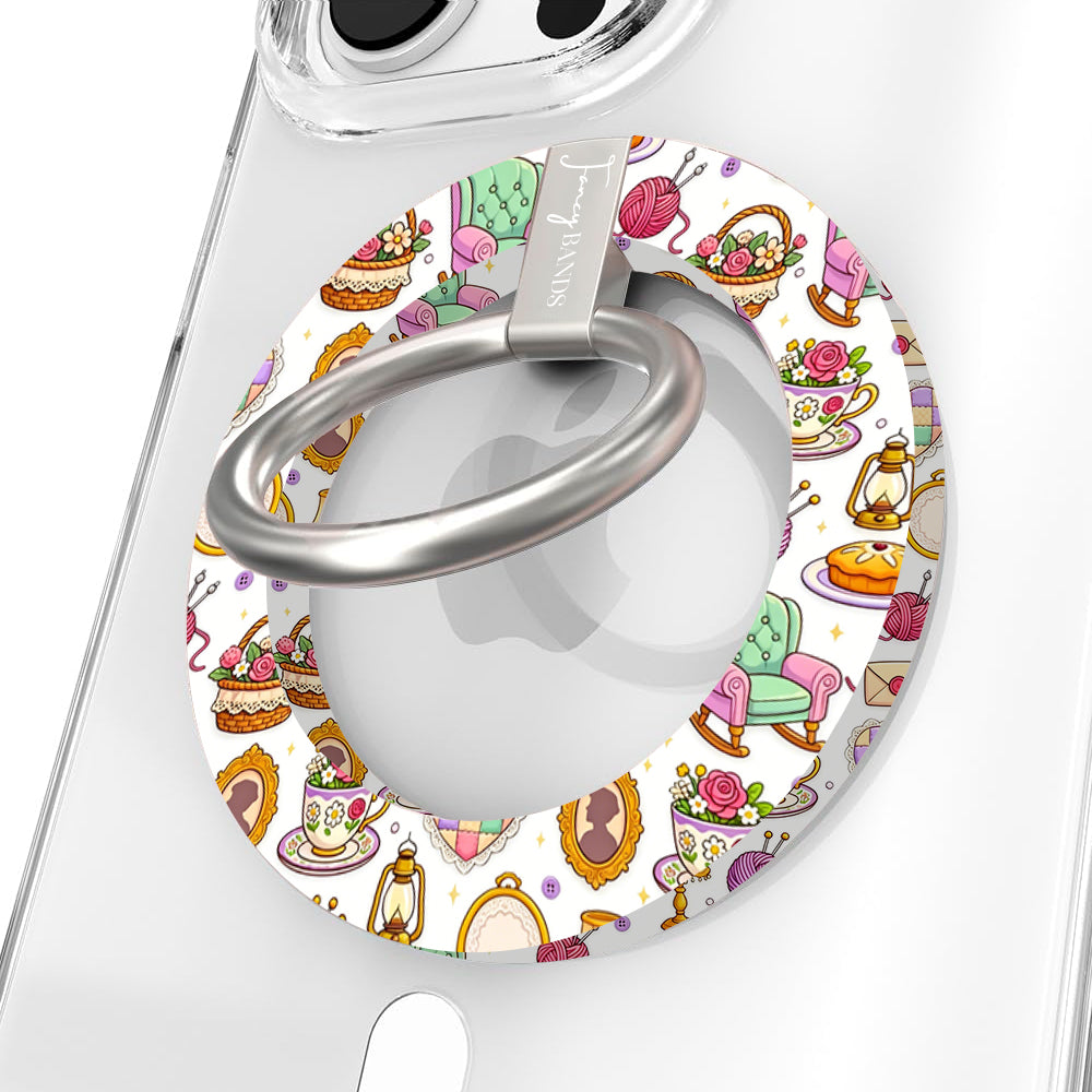 It's Giving Grandma Hobbies cozy grandmacore MagSafe phone grip ring with knitting yarn, rocking chairs, teacups, and pies on a white background compatible with iPhone and Samsung