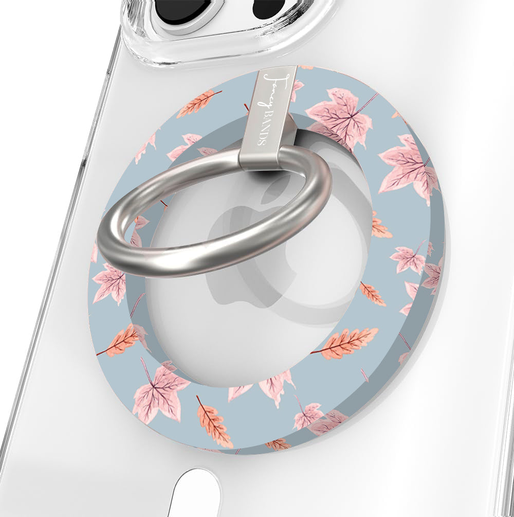 Autumn Breeze Hold It Fancy MagSafe grip ring close-up on a clear iPhone case, showing the slate blue ring with blush maple leaves and wheat sprigs around the silver rotating ring.