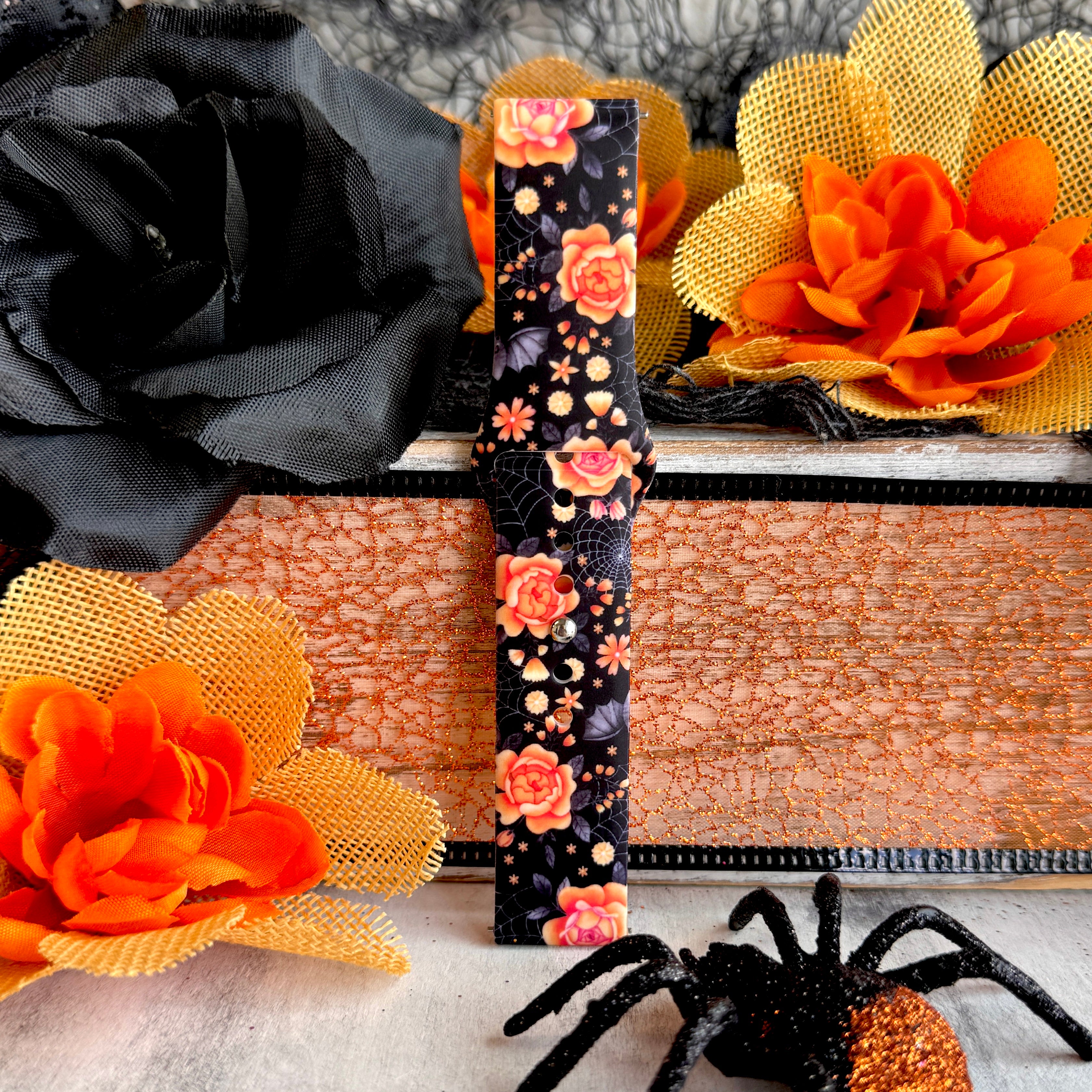Single Haunted Blossoms Samsung Galaxy Watch band strap standing tall showing coral roses and spiderwebs over black silicone.