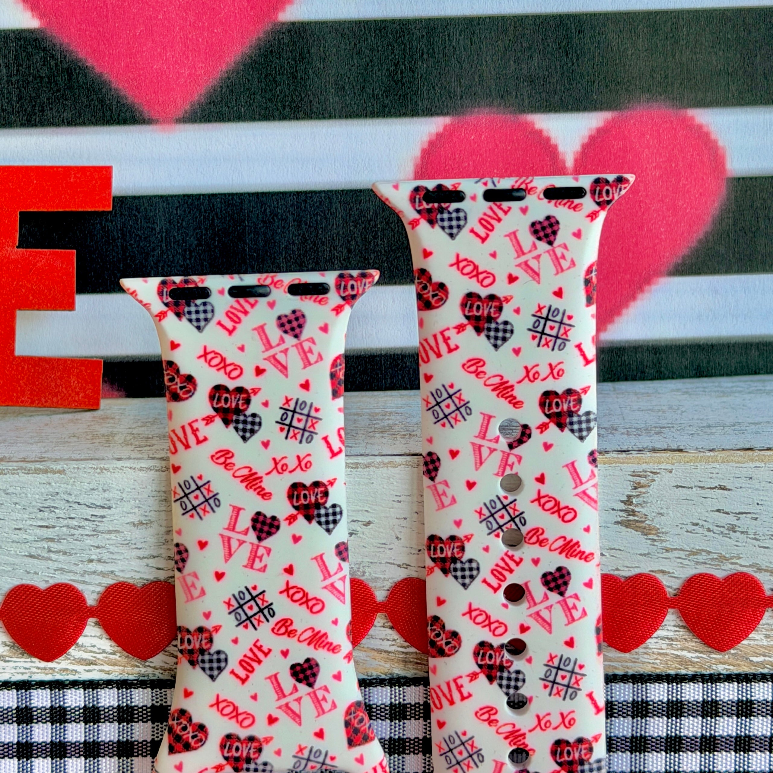 Tick-Tack-Love Apple Watch band with LOVE text, XOXO, and hearts in pink and red on white background with Valentine's decor