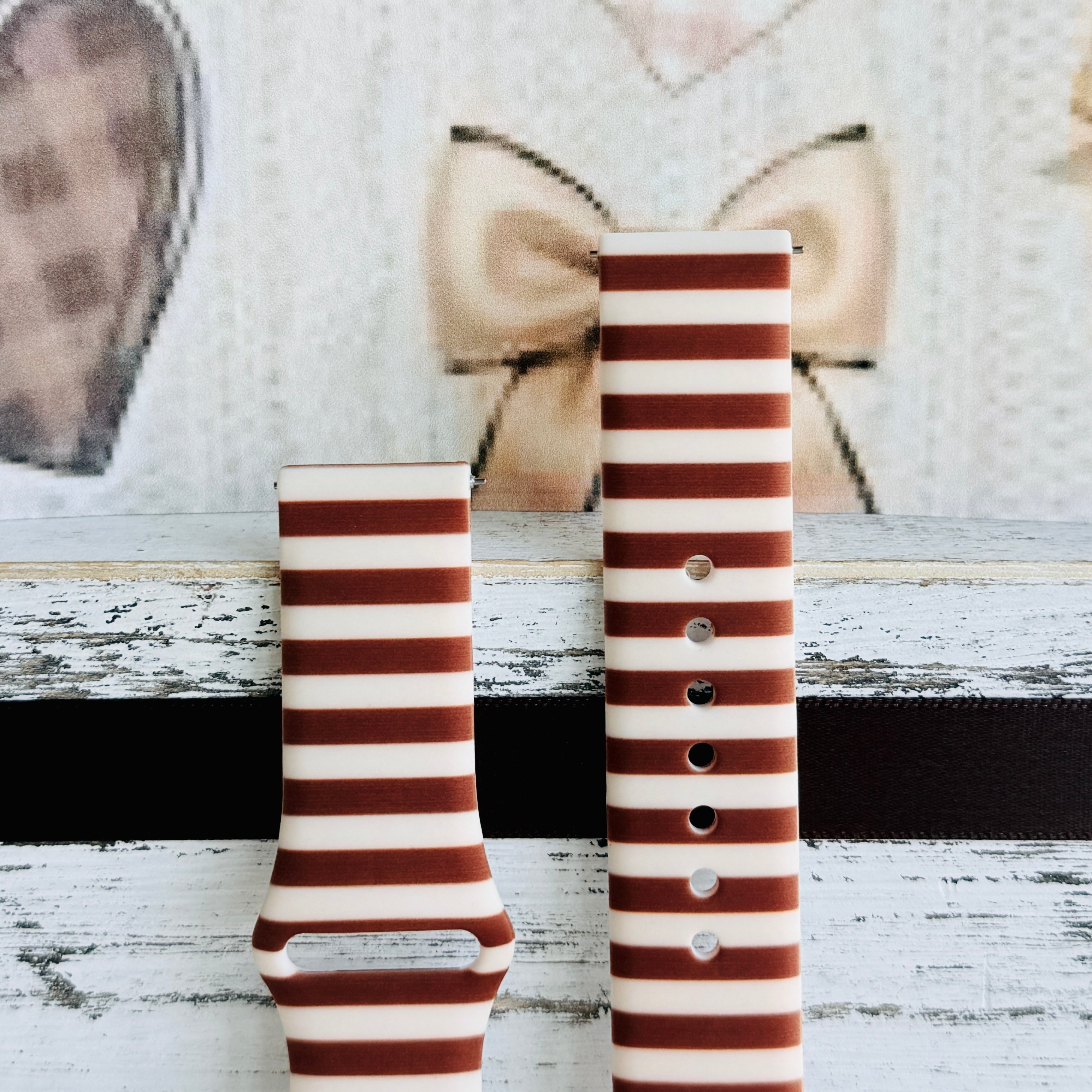 Sweet Espresso Stripes Samsung Galaxy Watch band front view of both strap halves against a cream knit and bow backdrop, showing the stripe repeat and quick-release pin holes.