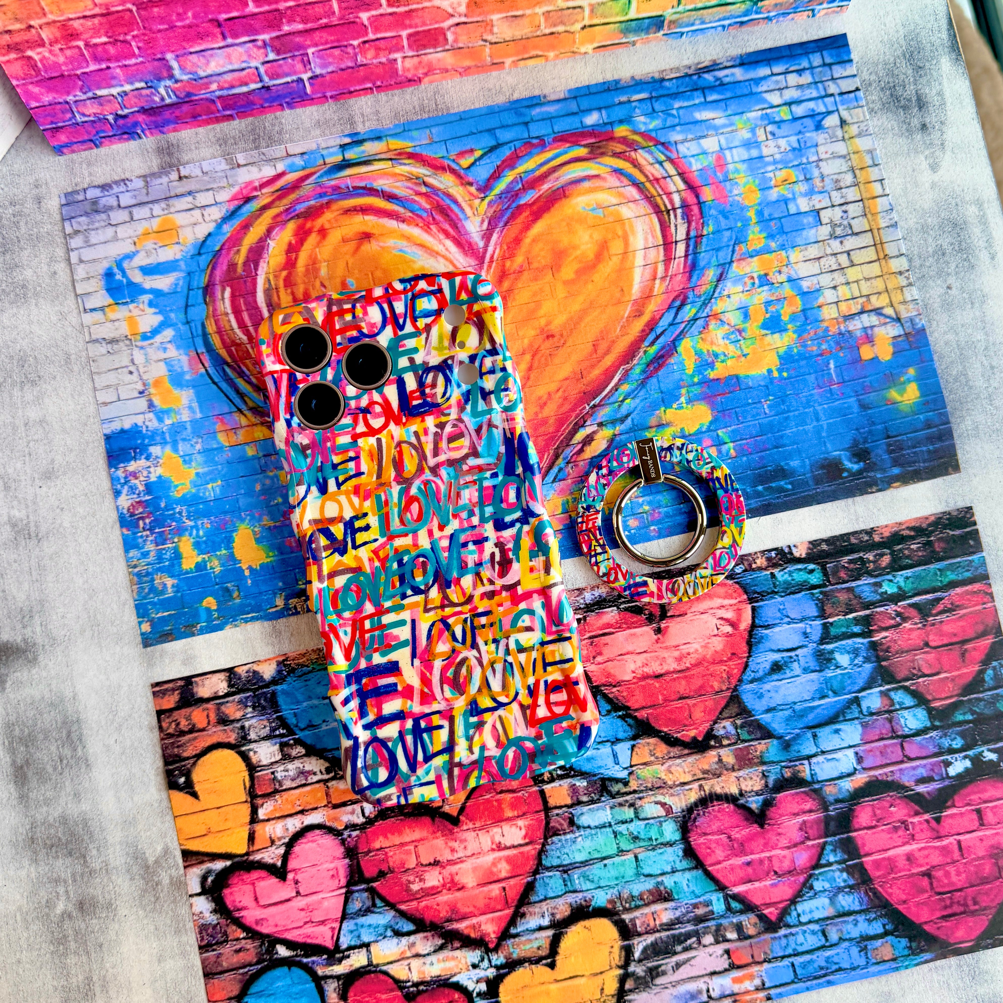 Love Riot graffiti street art MagSafe phone grip ring with colorful love text in pink teal and yellow on white background compatible with iPhone and Samsung