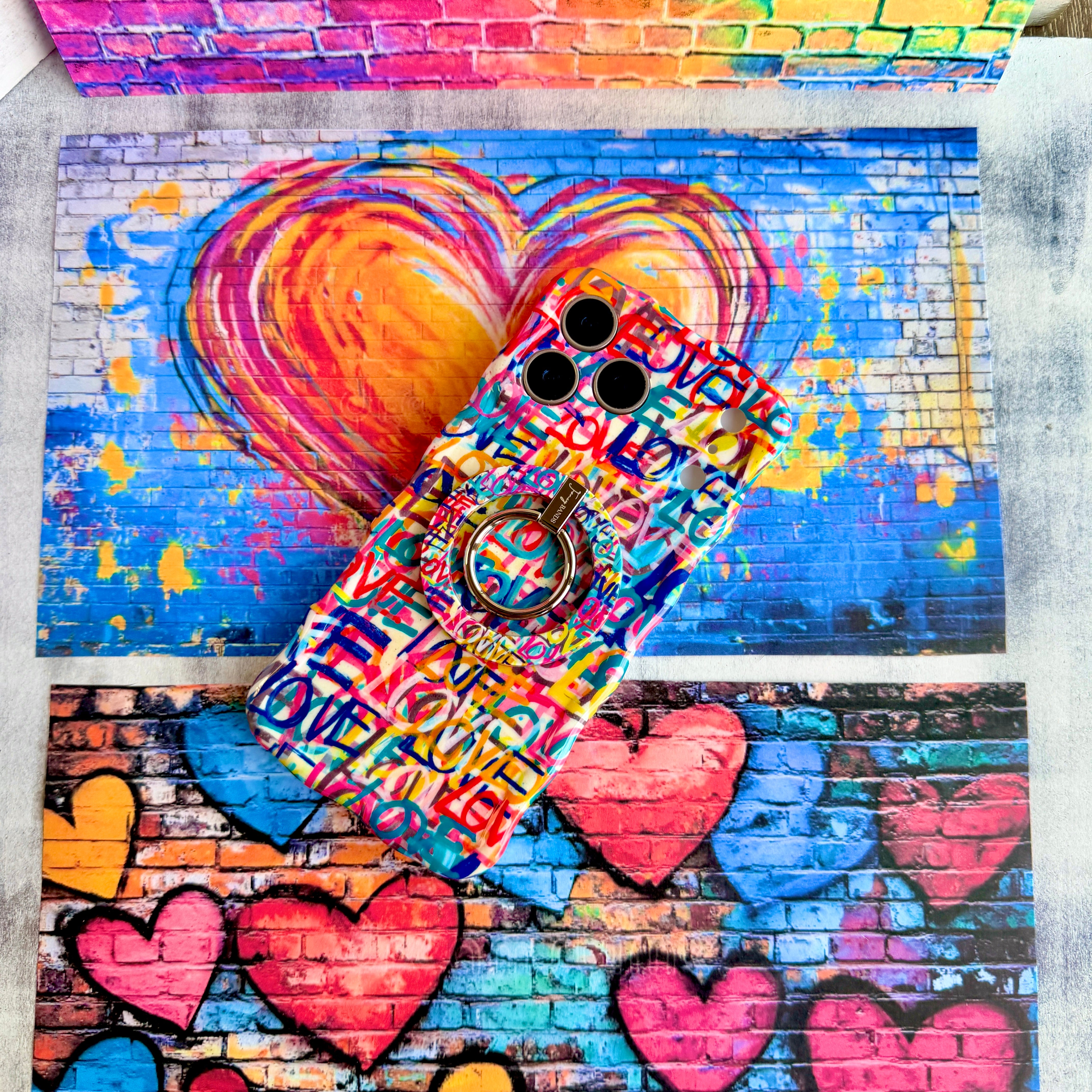 Love Riot graffiti street art MagSafe phone grip ring with colorful love text in pink teal and yellow on white background compatible with iPhone and Samsung