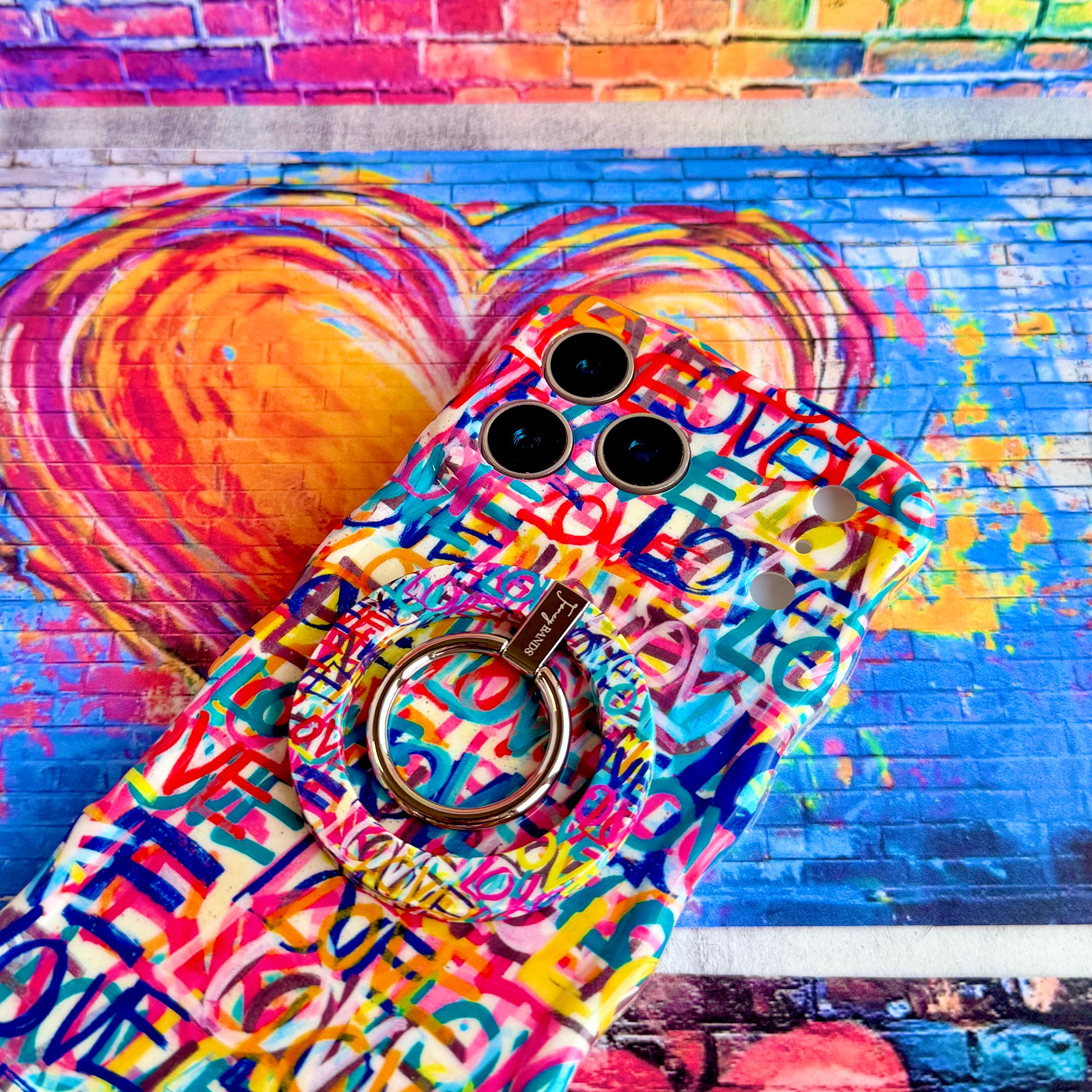 Love Riot graffiti street art MagSafe phone grip ring with colorful love text in pink teal and yellow on white background compatible with iPhone and Samsung