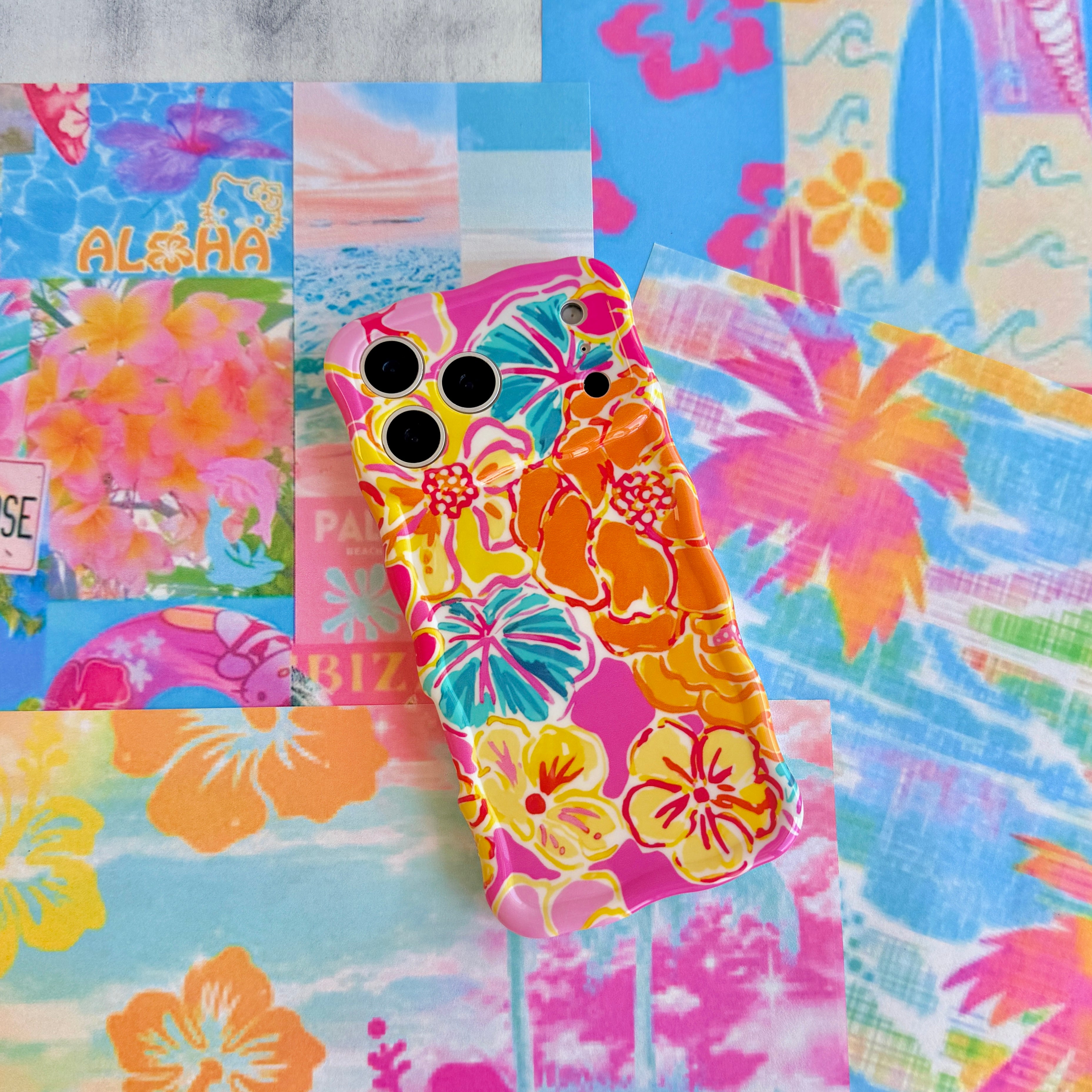 Trendy wavy iPhone case featuring a vibrant pink, orange, and teal hibiscus flower pattern with a high-gloss finish.