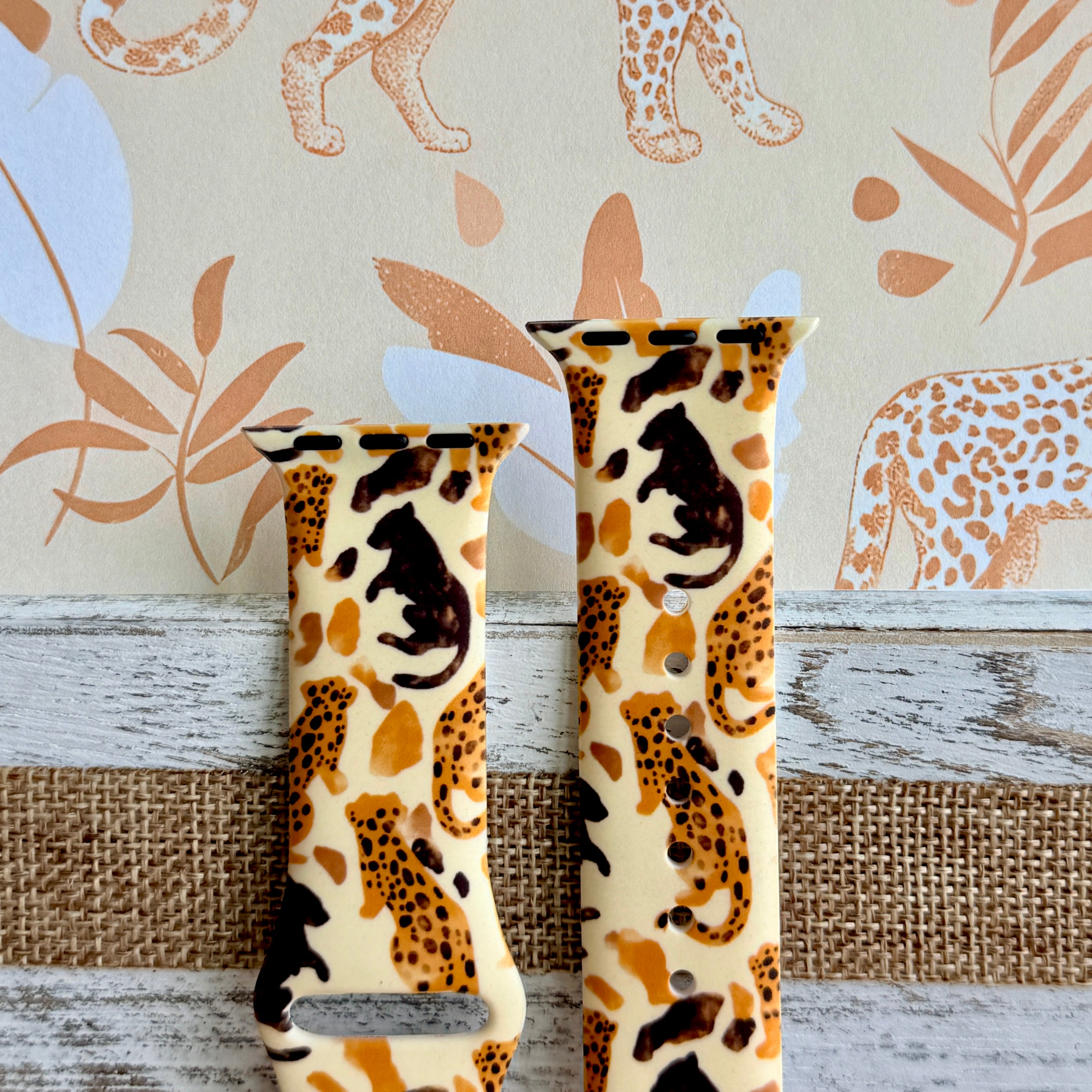 Golden Wildcat Apple Watch band with spotted leopards in golden and brown tones on cream background with safari wallpaper
