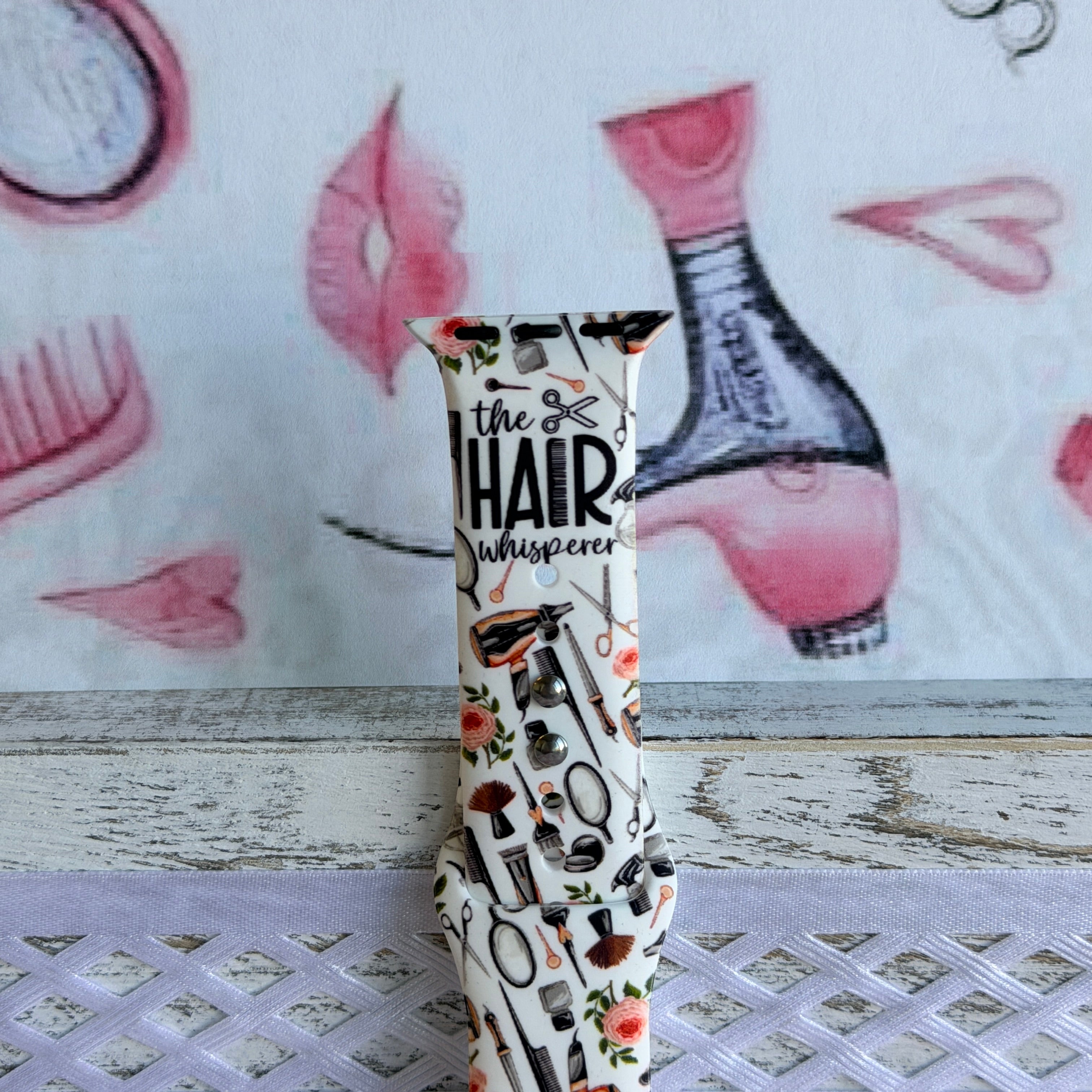 Hair Whisperer Apple Watch band with hairstyling tools, scissors, combs, and roses on white background with #HAIRLIFE backdrop