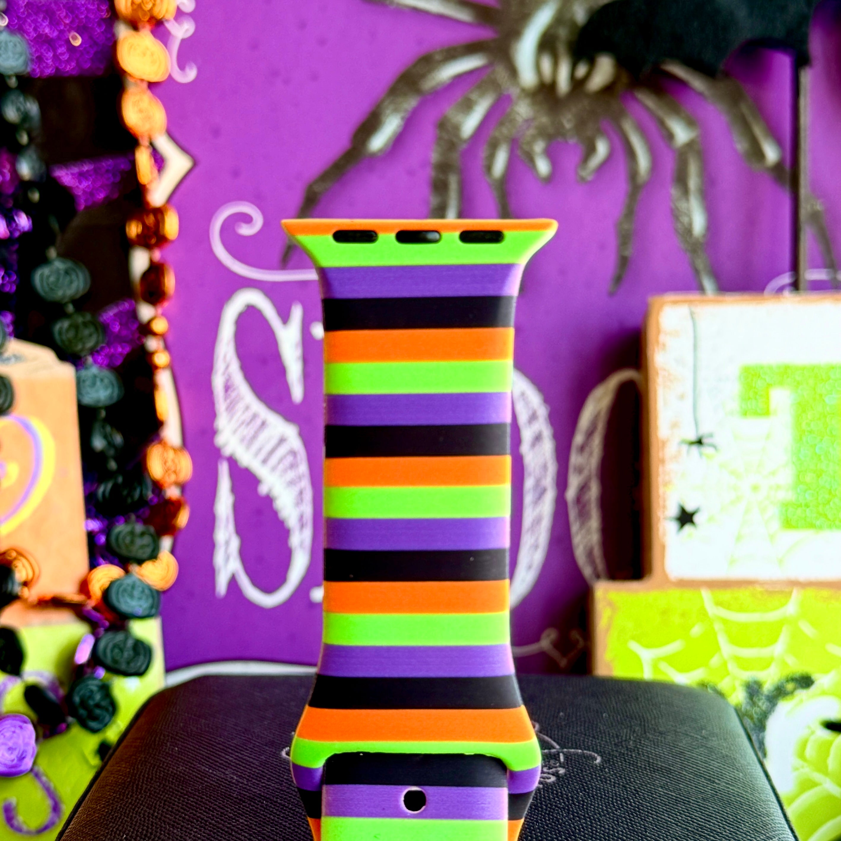 Close-up of the Main Witch Energy Apple Watch band showing the crisp black, purple, neon green and orange stripe edges.