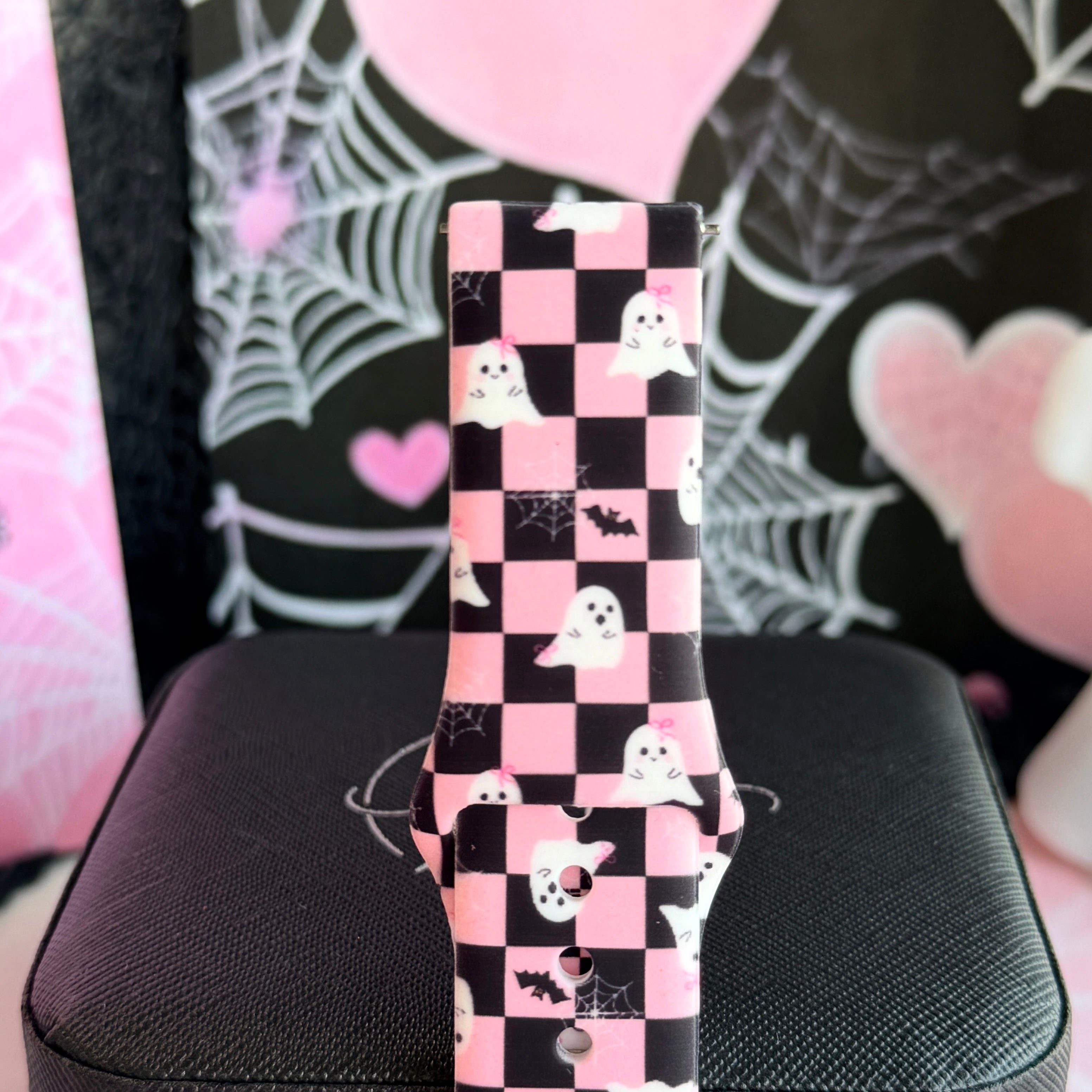Close view of the Hey Boo, Looking Cute Samsung Galaxy Watch band showing white ghosts and black bats on the pink and black checkerboard.