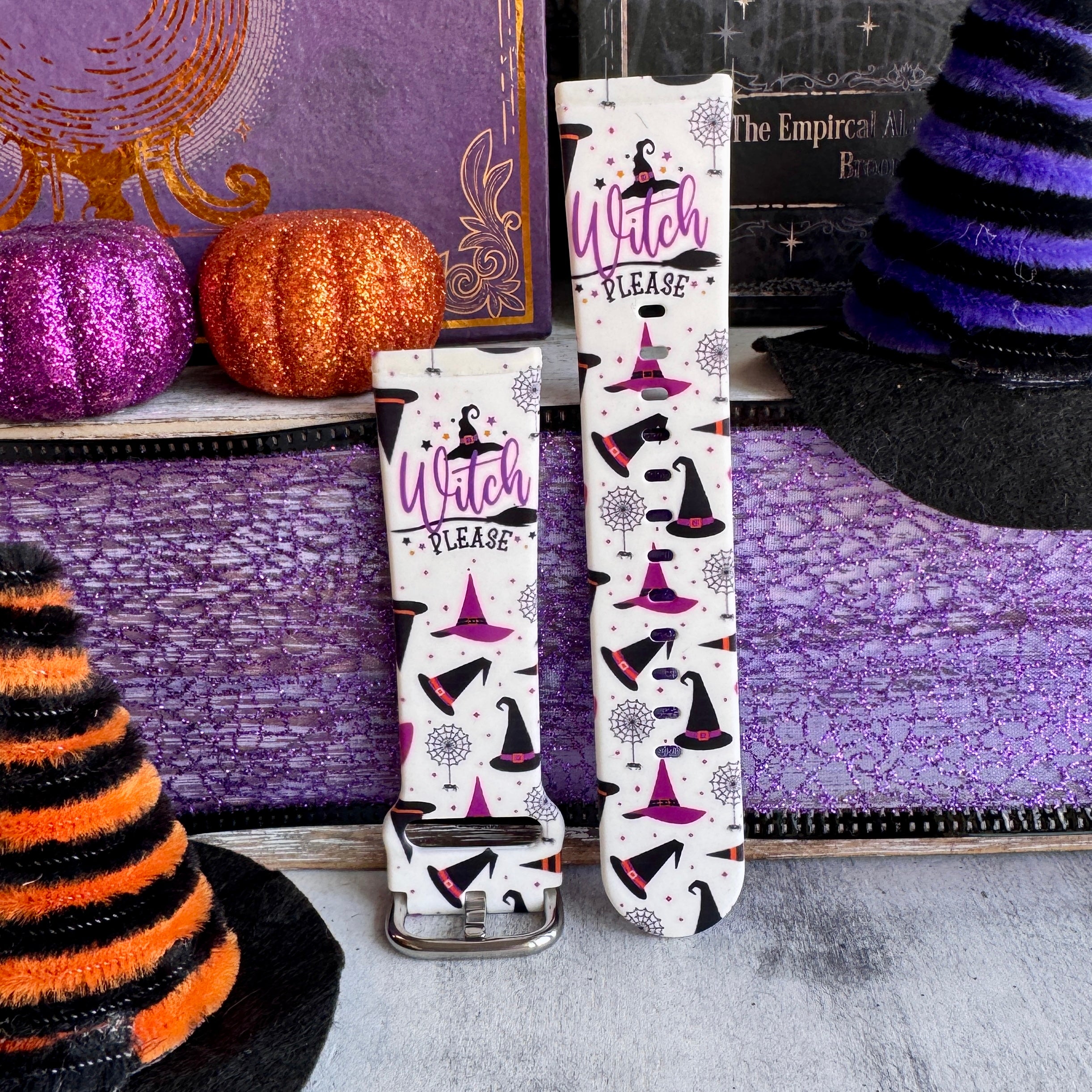 Two Witch Please Fitbit Versa 3/4 and Sense band straps standing with the buckle visible and witch hats across the cream silicone.
