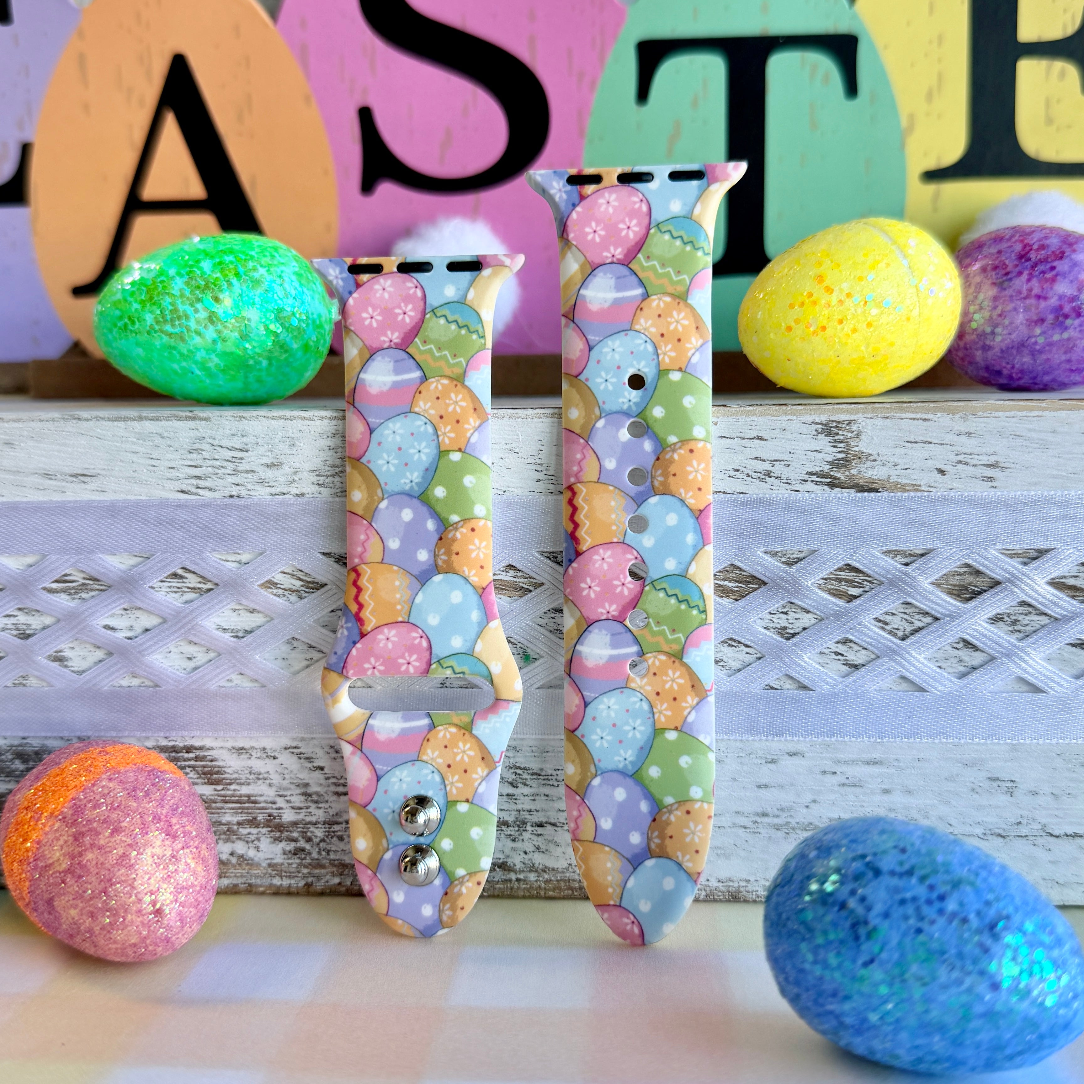 Egg-stra Cute Apple Watch band with colorful pastel Easter eggs displayed with glittery eggs and Easter decorations