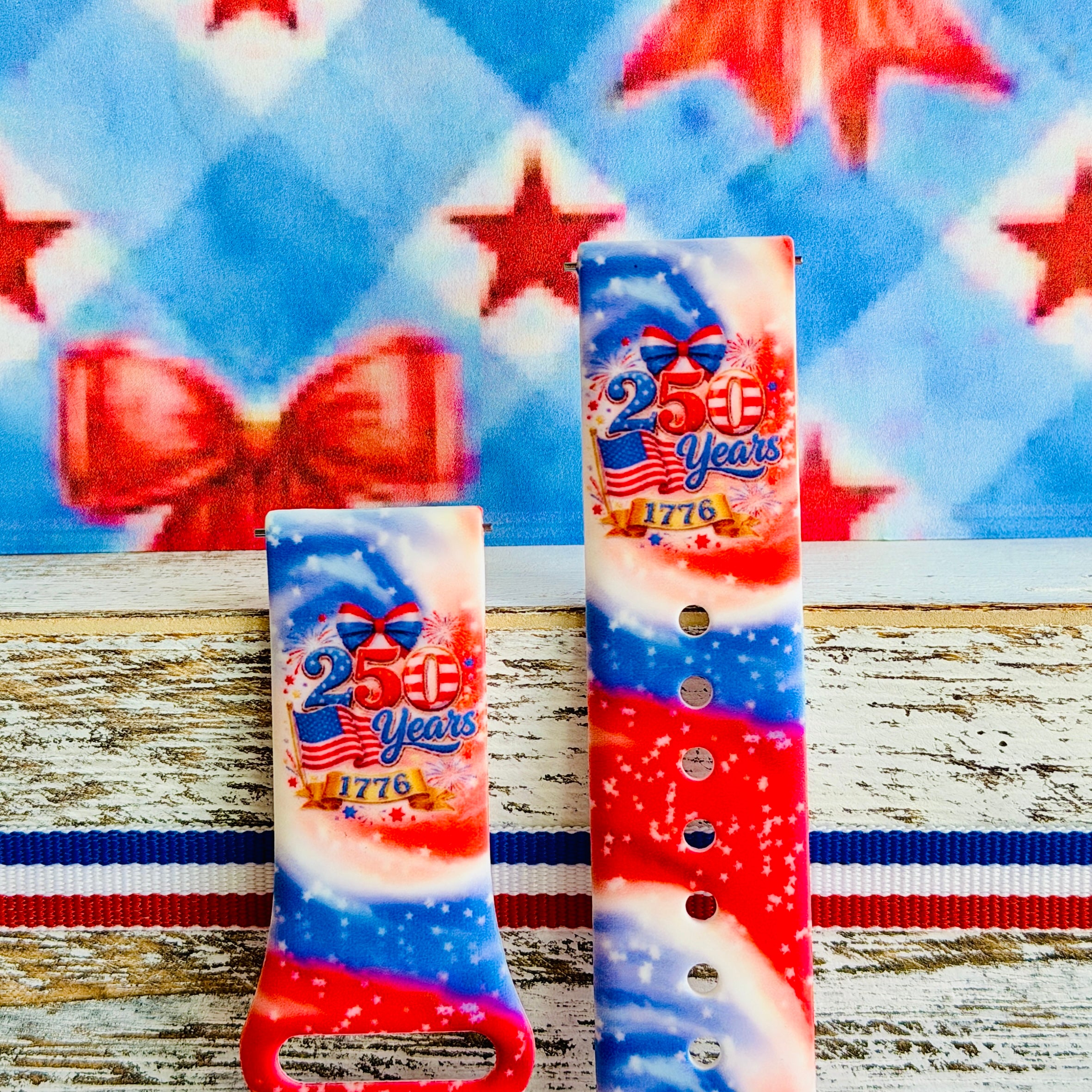 Sweet Freedom 250 silicone Samsung Galaxy Watch band celebrating America's 250th anniversary with "250 Years 1776" emblem, American flag, fireworks, red bow, and red, white, and blue tie-dye swirl with star sparkle, shown displayed and worn against a patriotic 4th of July backdrop.