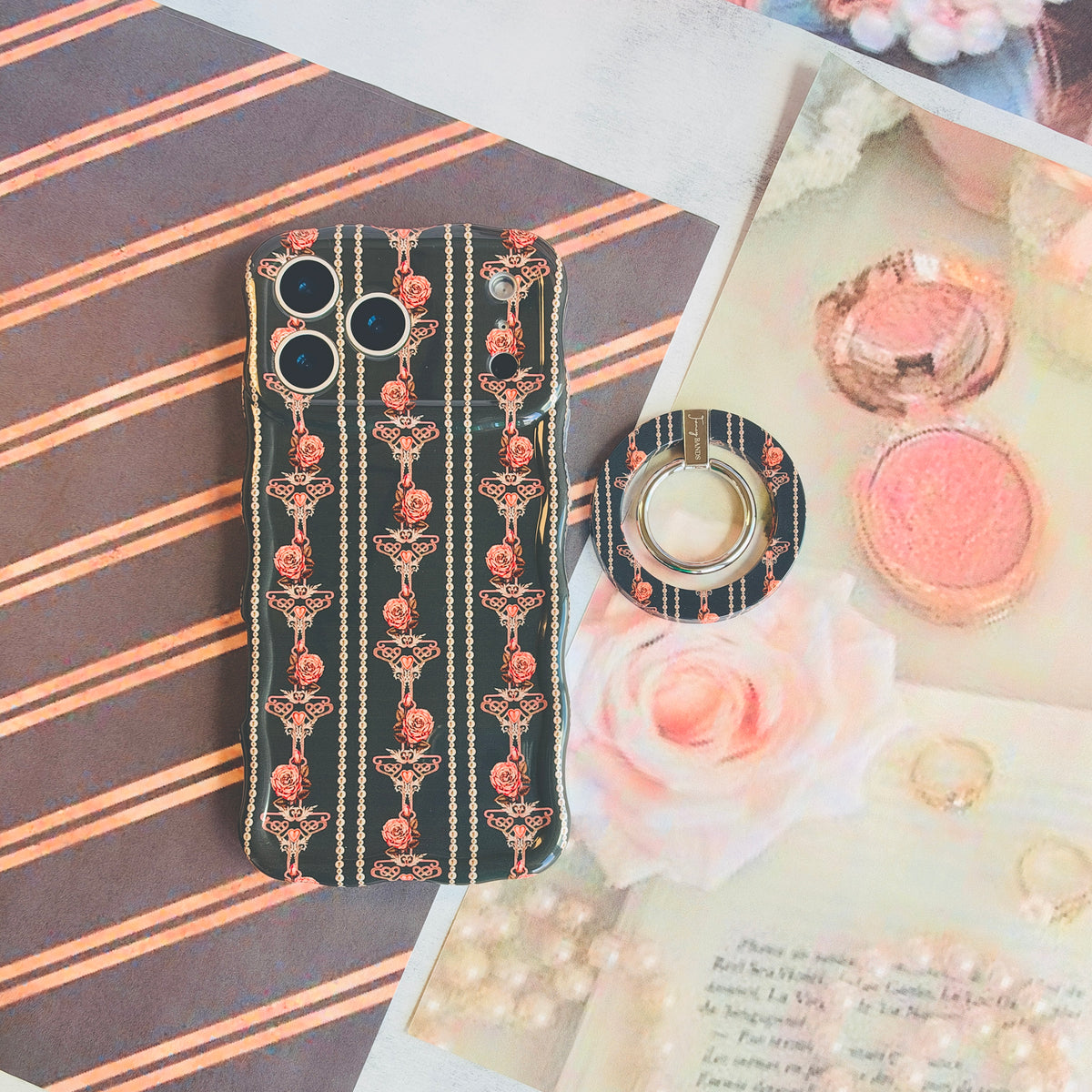 Pretty Little Details MagSafe grip ring shown beside its matching black pearl and rose iPhone case with a blush compact and pink rose prints.