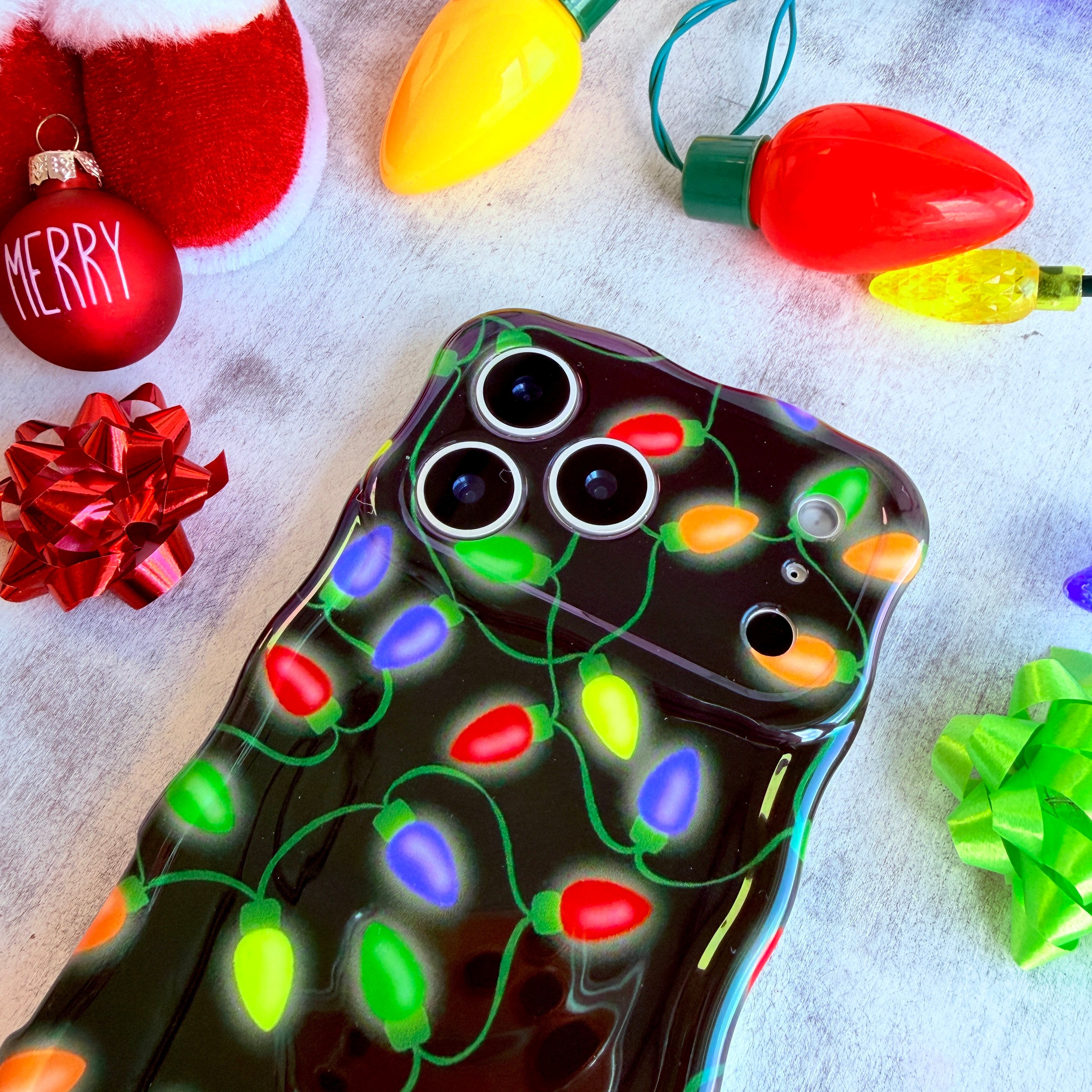 Glossy black holiday MagSafe iPhone case with Christmas light bulbs