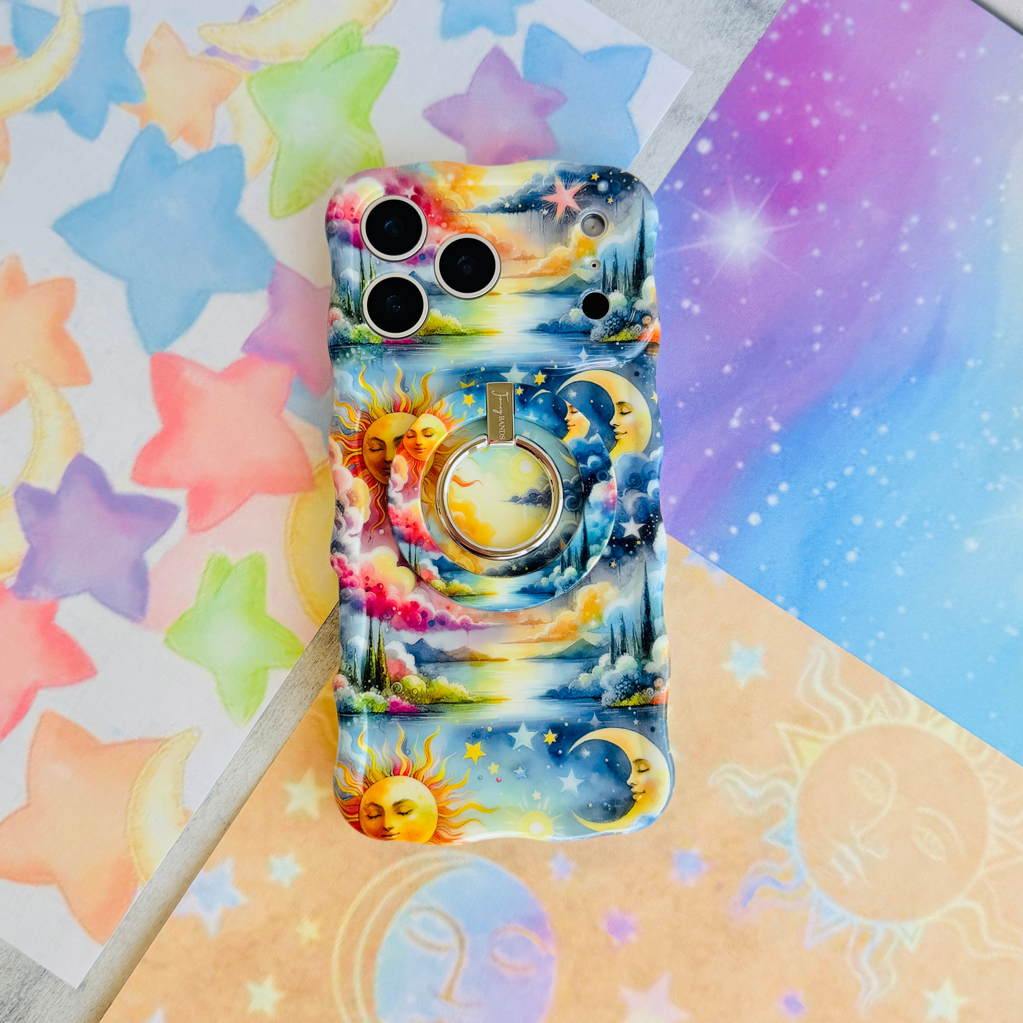 Cosmic Daydream celestial MagSafe phone grip ring with watercolor illustration of a personified sun, crescent moon, and stars in a dreamlike landscape compatible with iPhone and Samsung