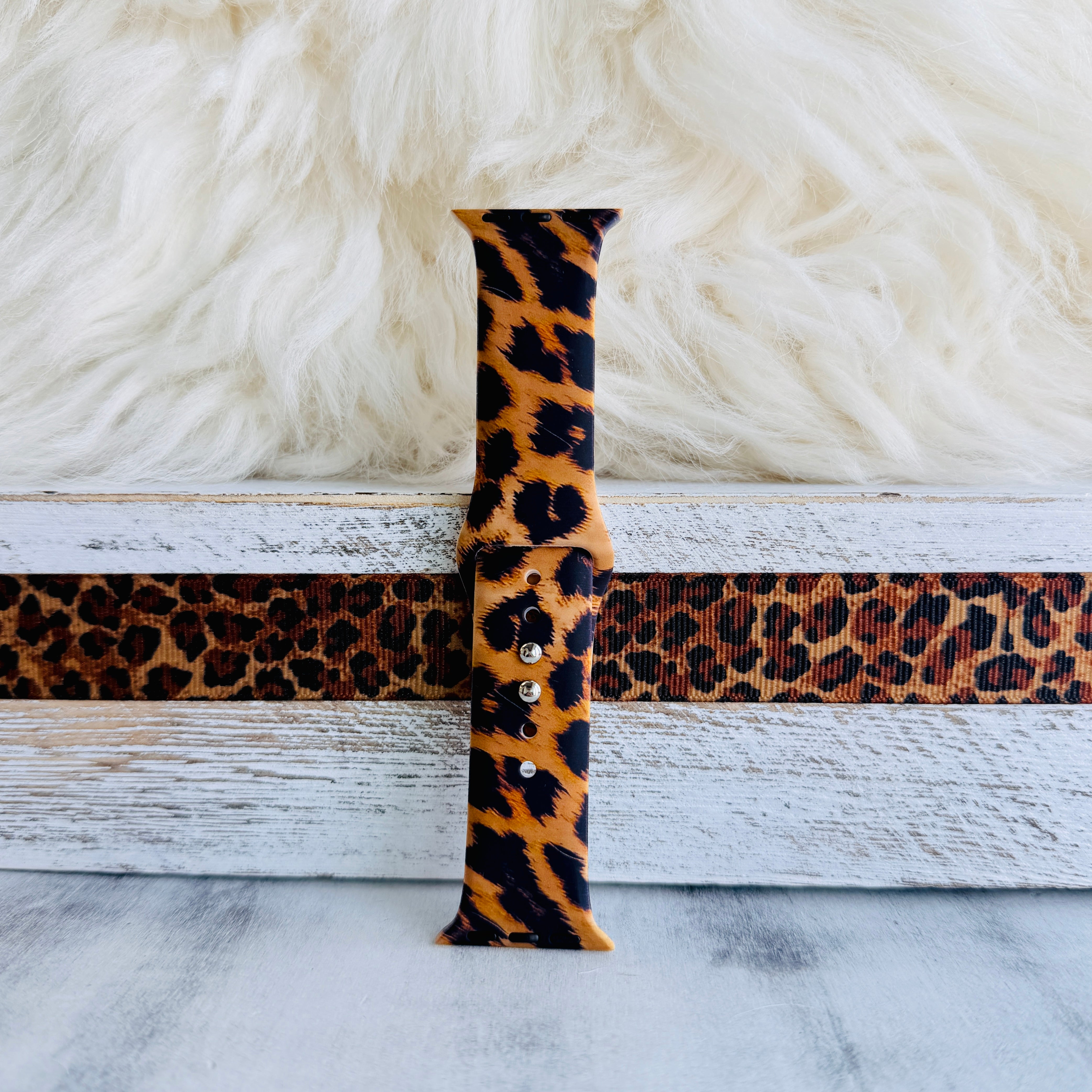 Rawr Mode Apple Watch band with bold tan and black leopard print pattern on white fur background
