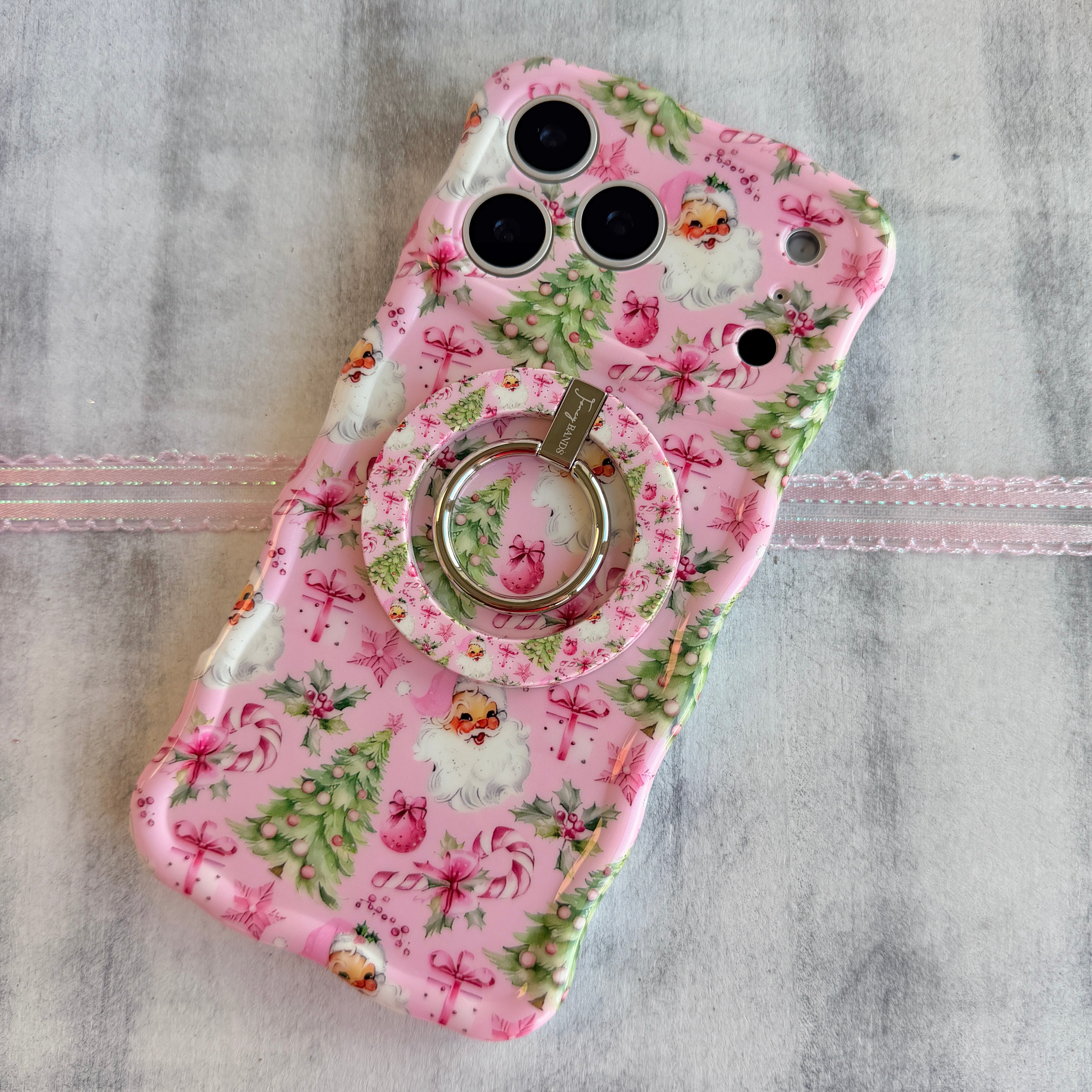 Pink floral phone case with a ring holder on a gray background