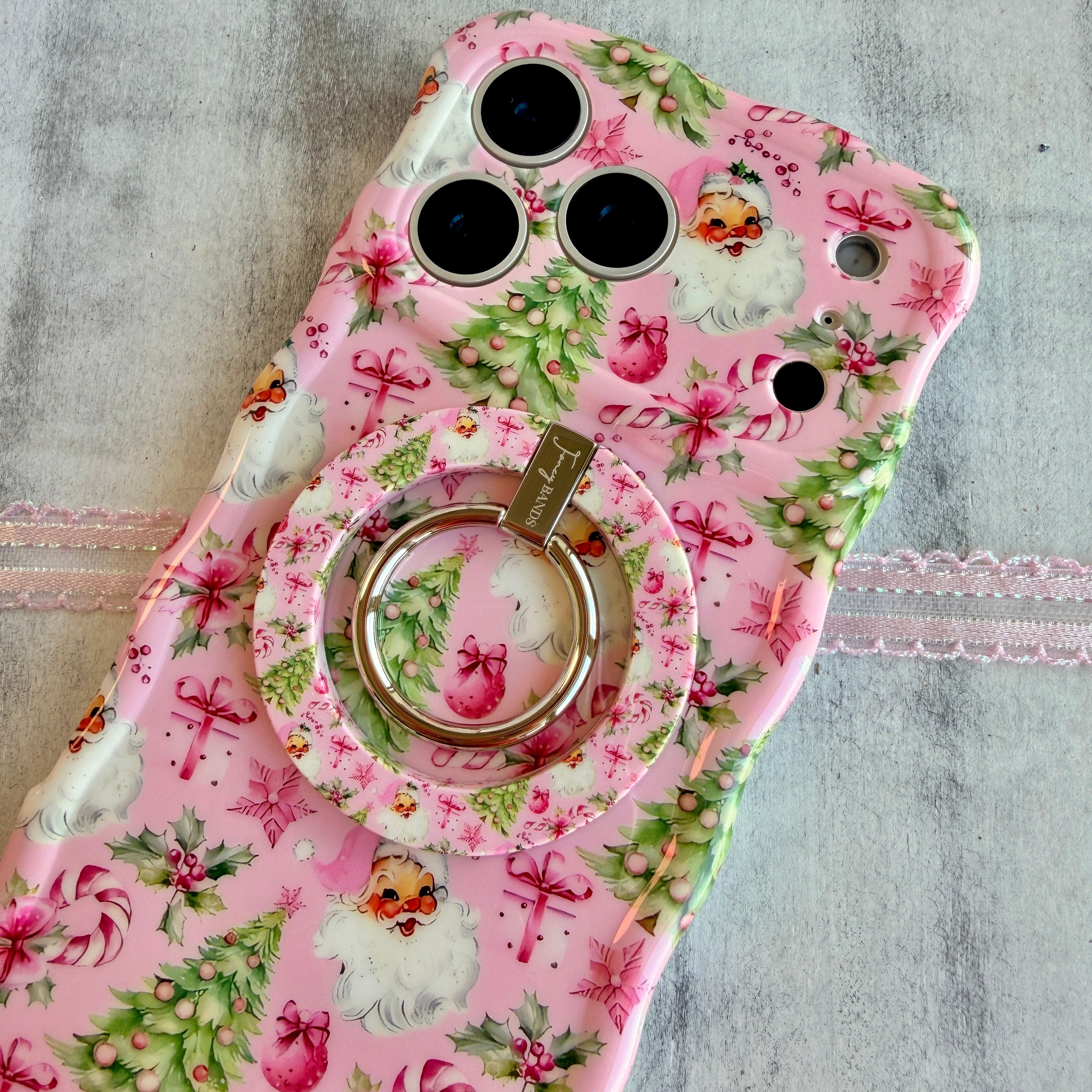 Pink floral phone case with a ring holder on a gray surface