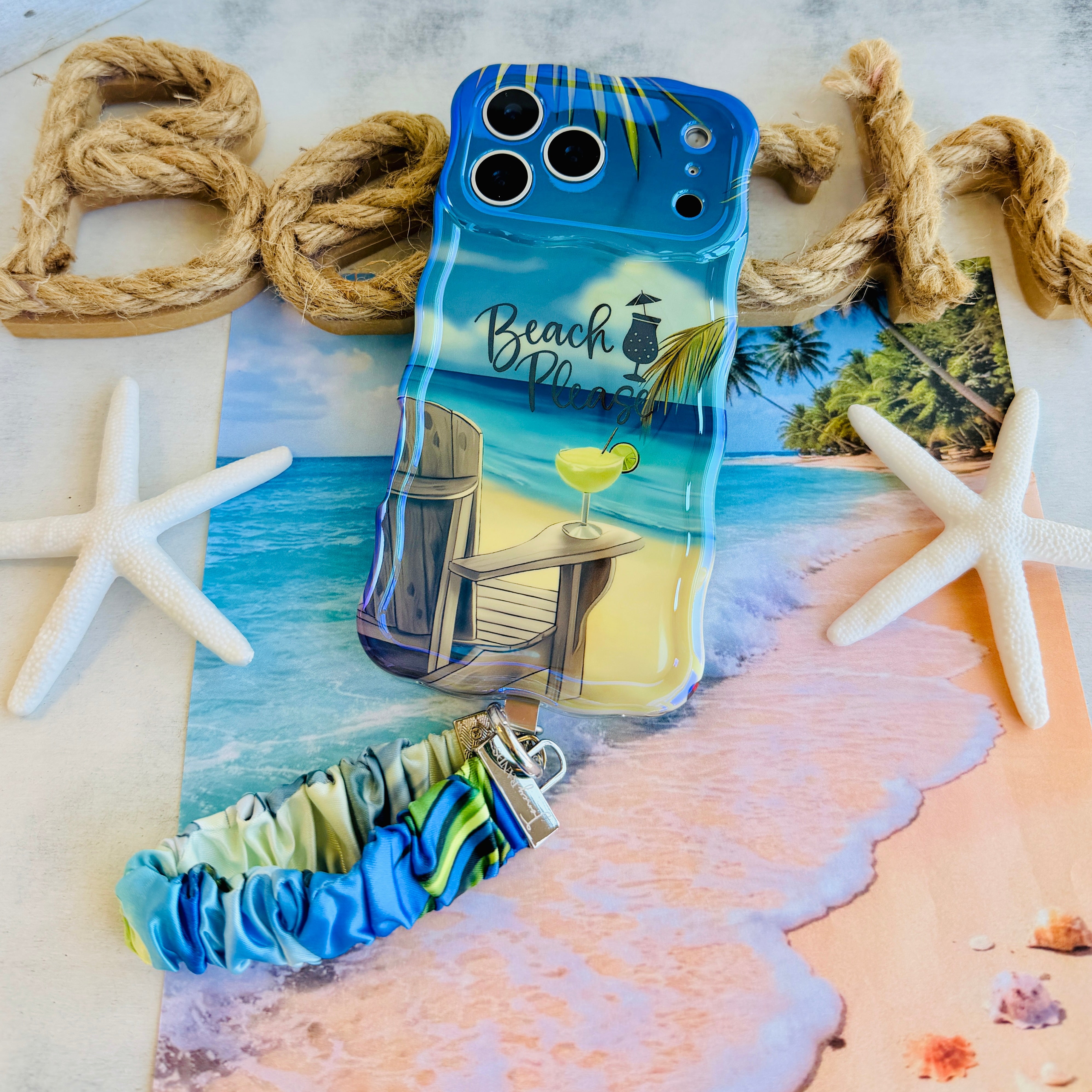 Beach Please scrunchie phone wrist strap clipped to the matching Beach Please Wavy Luxe iPhone case