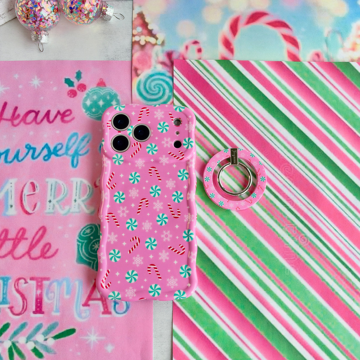 Peppermint Cutie MagSafe grip ring beside the matching iPhone case on pink, green and white candy stripe paper