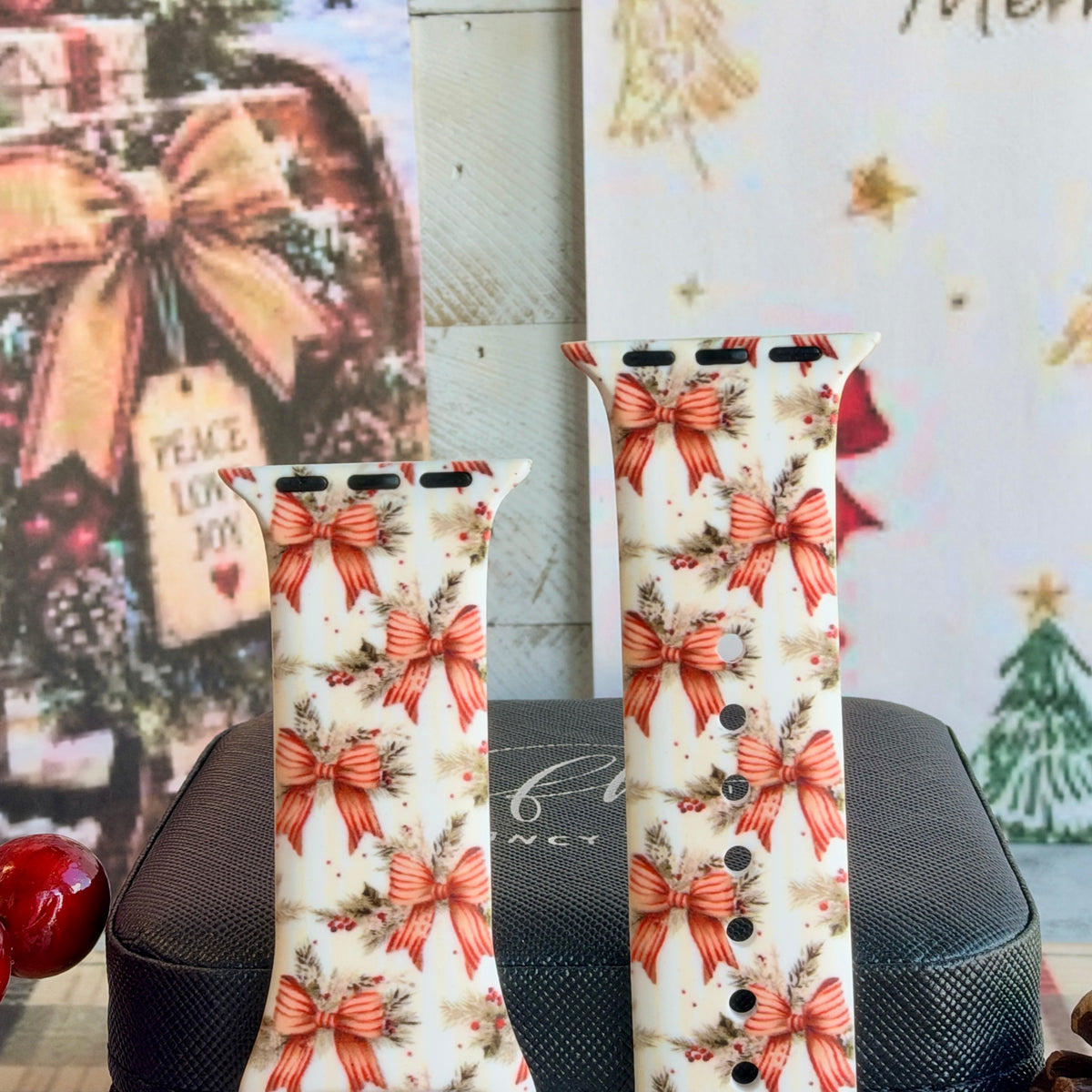 Close-up of both Deck Yourself in Bows & Holly Apple Watch band straps with striped red ribbon bows, pine and holly berries