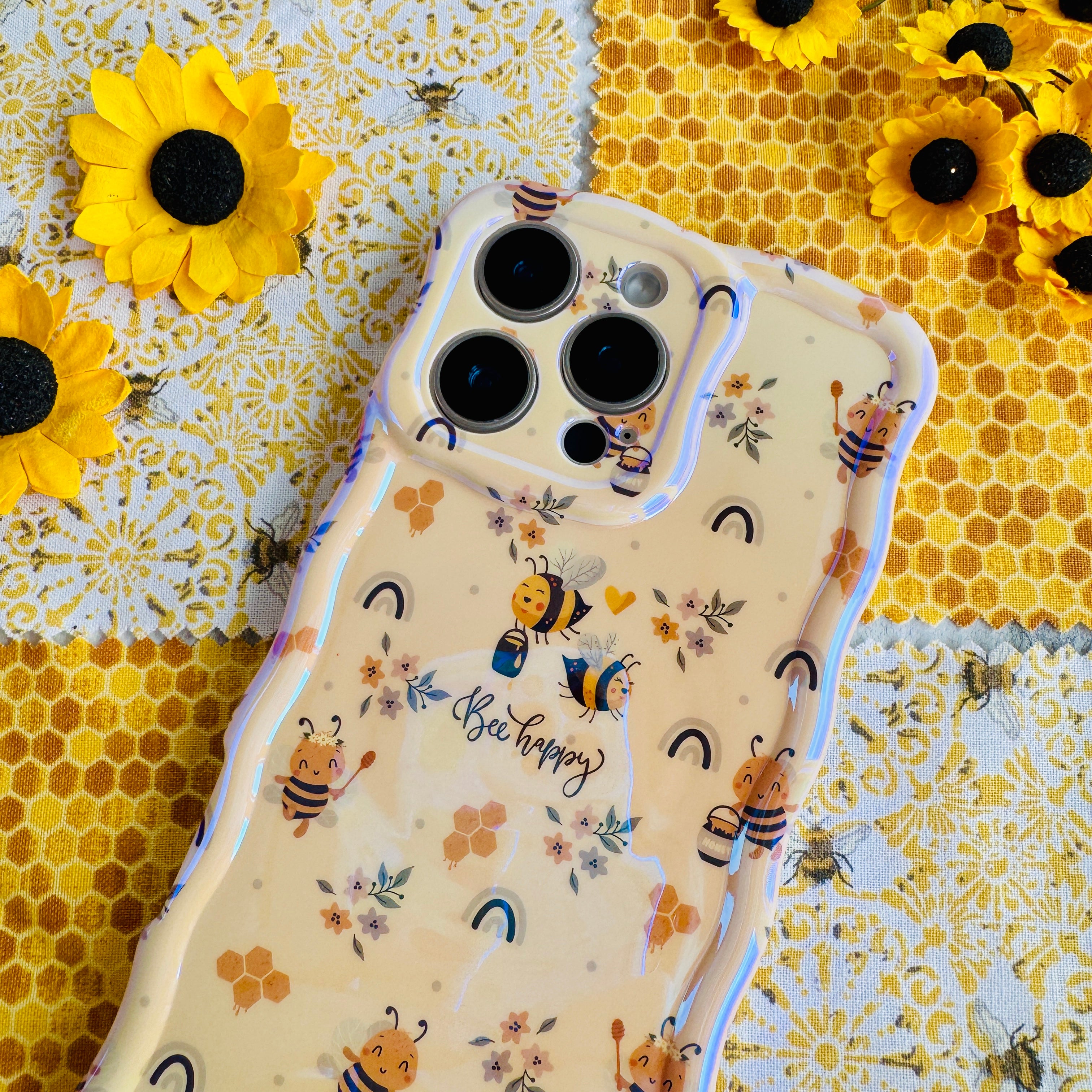 Phone case with bee and floral design on a yellow honeycomb background.