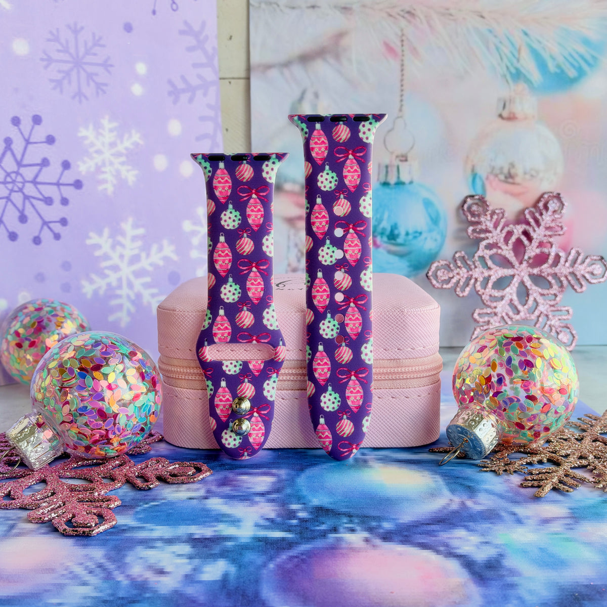 Just One More Ornament Apple Watch band buckled and standing on a pink jewelry box between confetti ornaments and pink glitter snowflakes