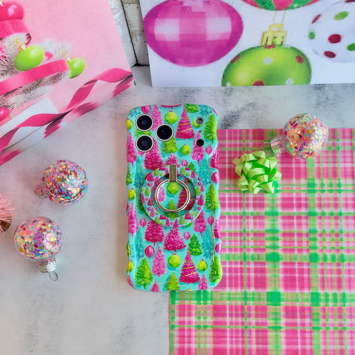Merry & Bright, Totally! MagSafe grip ring snapped onto the matching Christmas tree iPhone case, on pink and green plaid with confetti ornaments