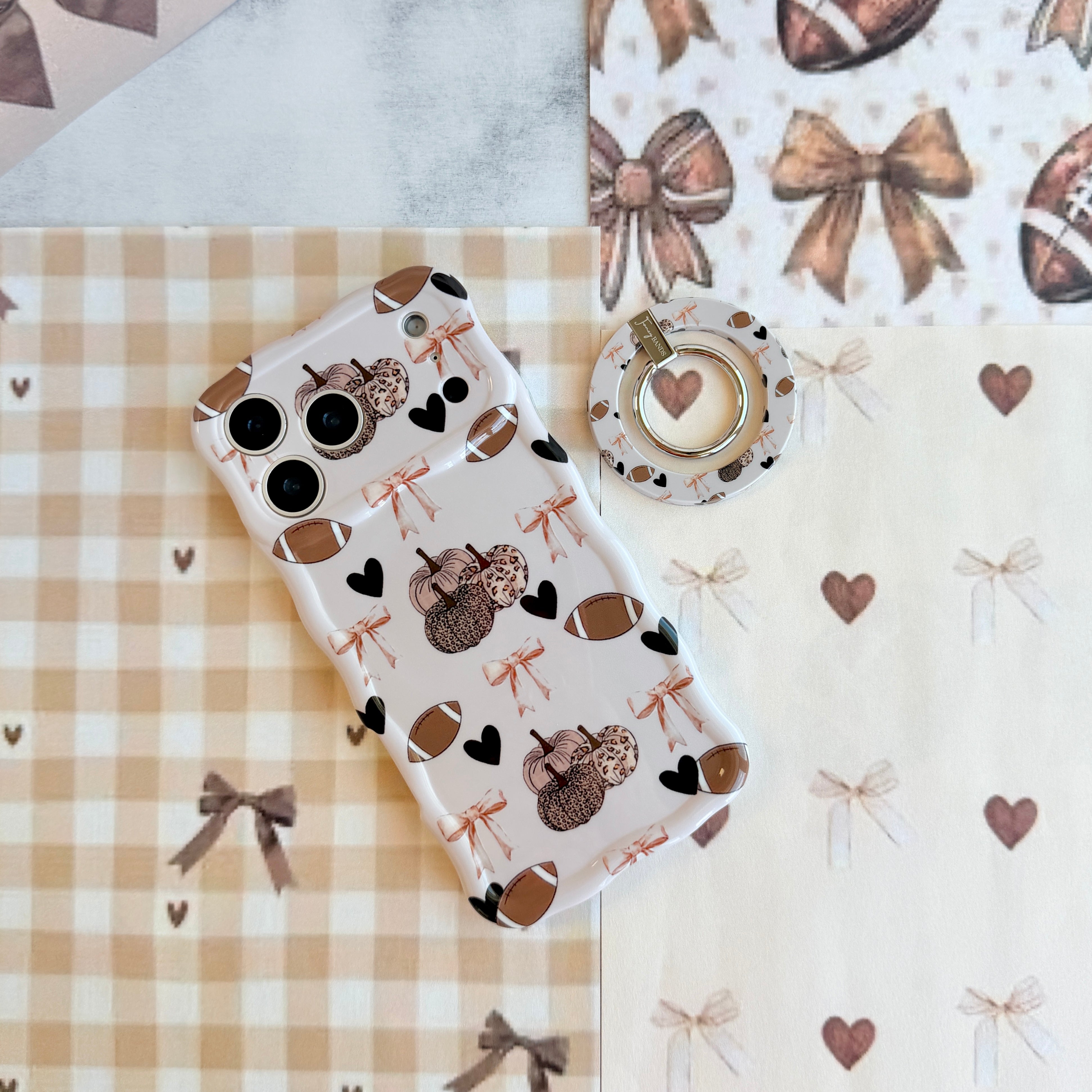 Game Day Darling Hold It Fancy MagSafe grip ring with a cream coquette print of footballs, leopard pumpkins, bows and hearts from Fancy Bands