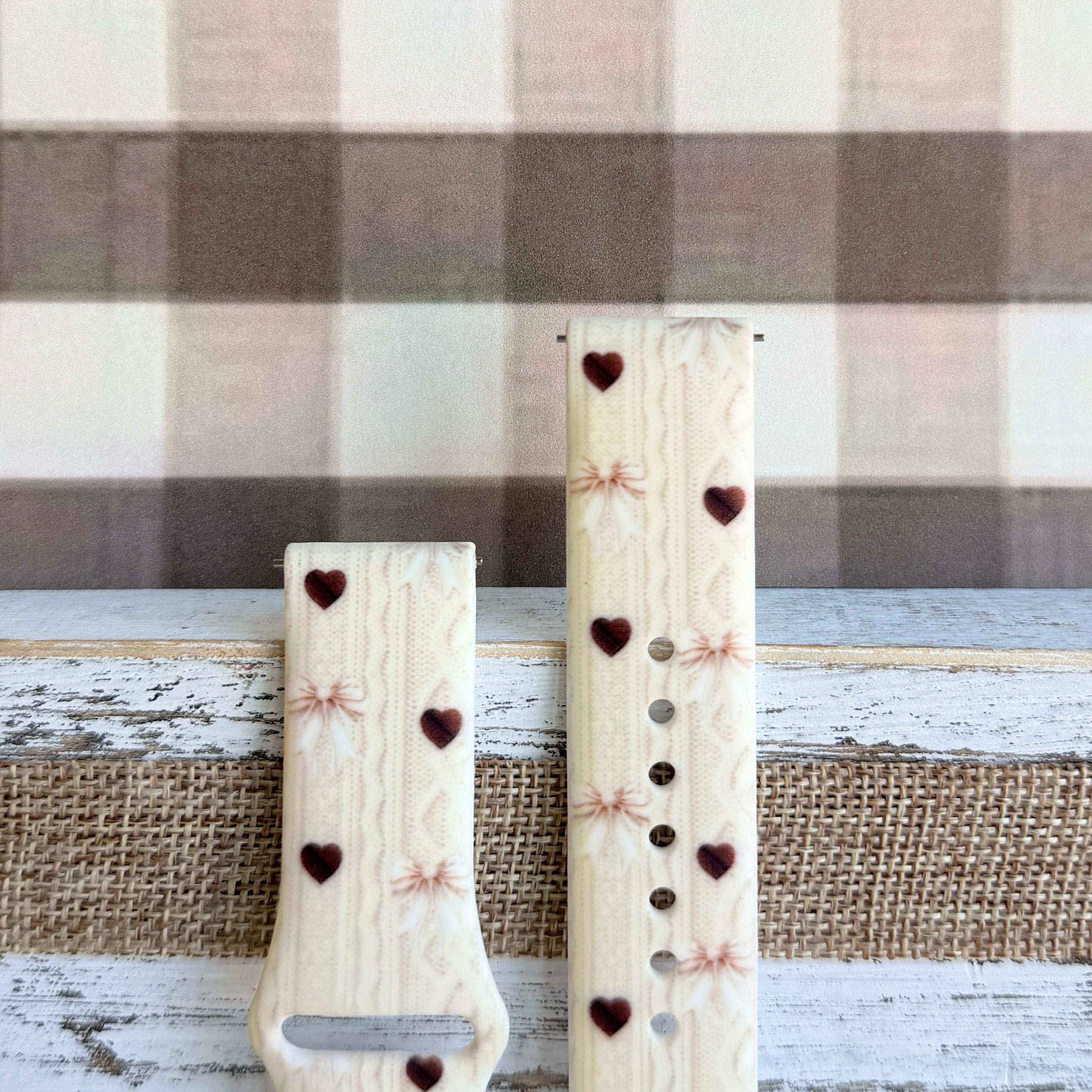 Sweater Weather Sweetheart Samsung Galaxy Watch band flat lay showing the full silicone strap with cream knit texture, taupe bows, and brown heart print.