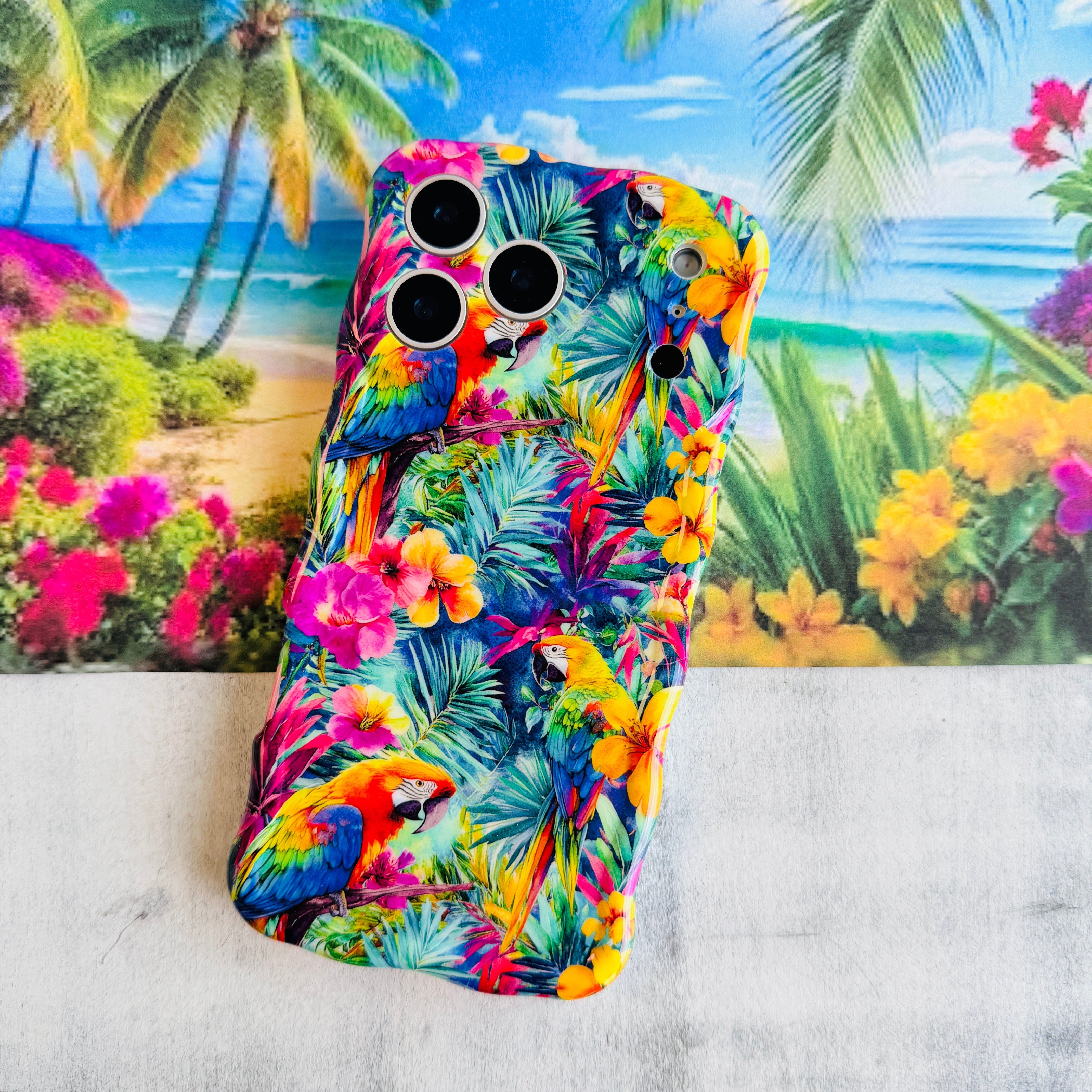 Trendy wavy iPhone case featuring a vibrant tropical pattern of red macaws, pink hibiscus, and green palm leaves with a high-gloss finish.