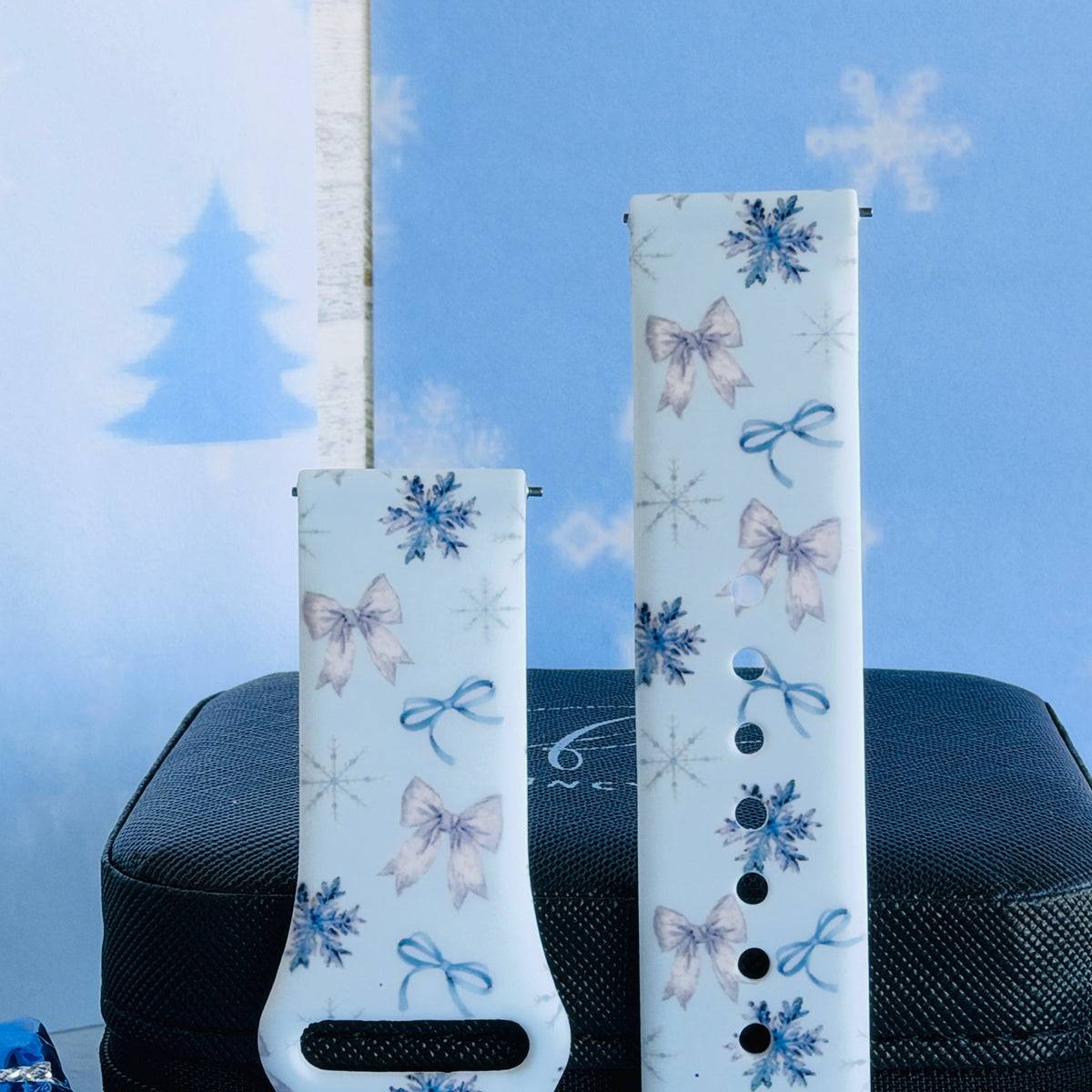 Close-up of both Snow Pretty In Blue Samsung Galaxy Watch band straps with silvery satin bows, blue ribbon bows and navy snowflakes