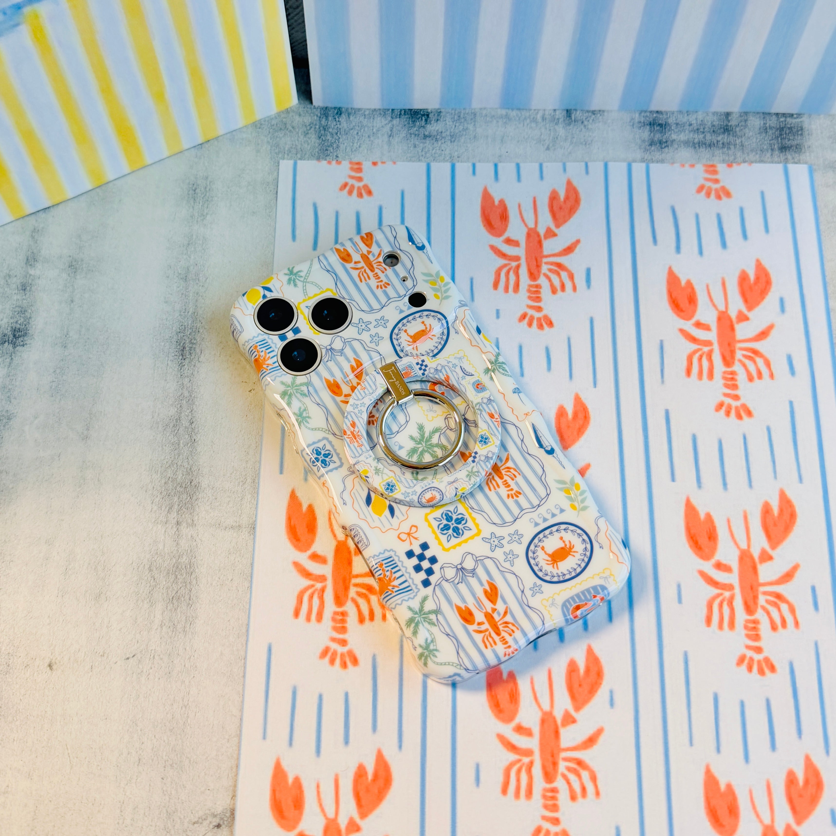 Coastal Catch MagSafe phone grip ring with orange lobster, blue stripes, and nautical postage stamp pattern compatible with iPhone and Samsung