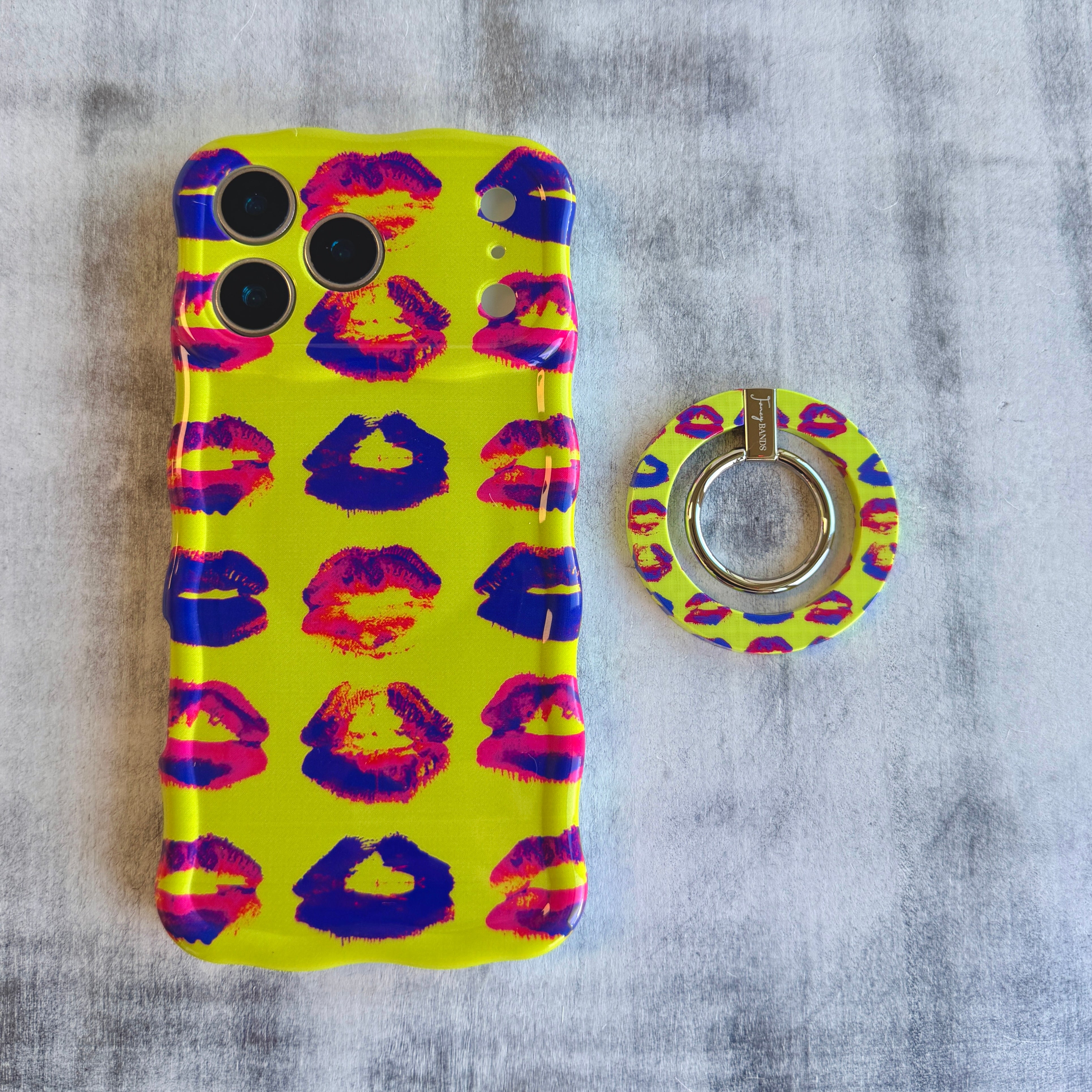 Lip Pop pattern MagSafe phone grip ring with neon pink and purple lip prints on bright yellow background compatible with iPhone and Samsung