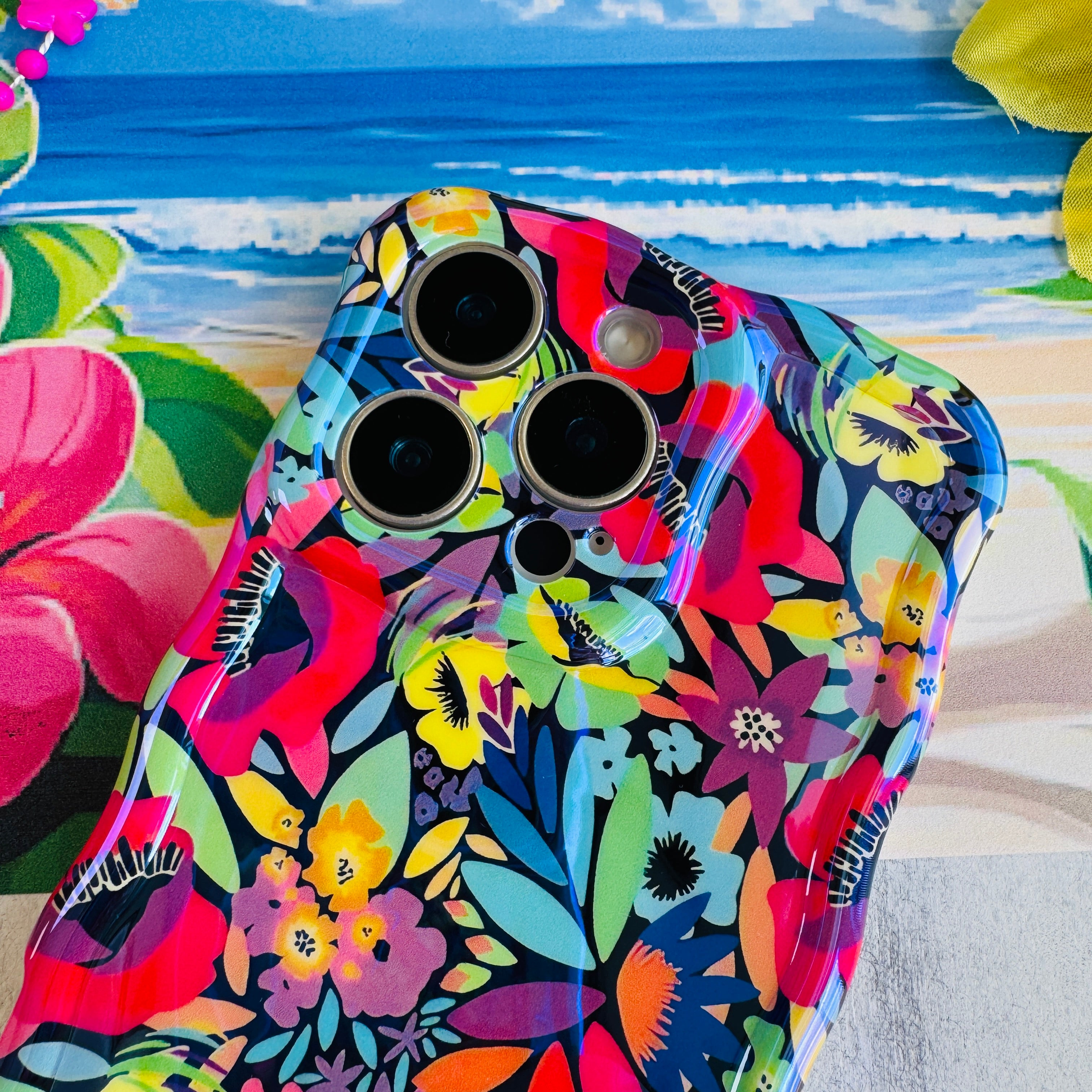 Colorful floral phone case on a beach-themed background