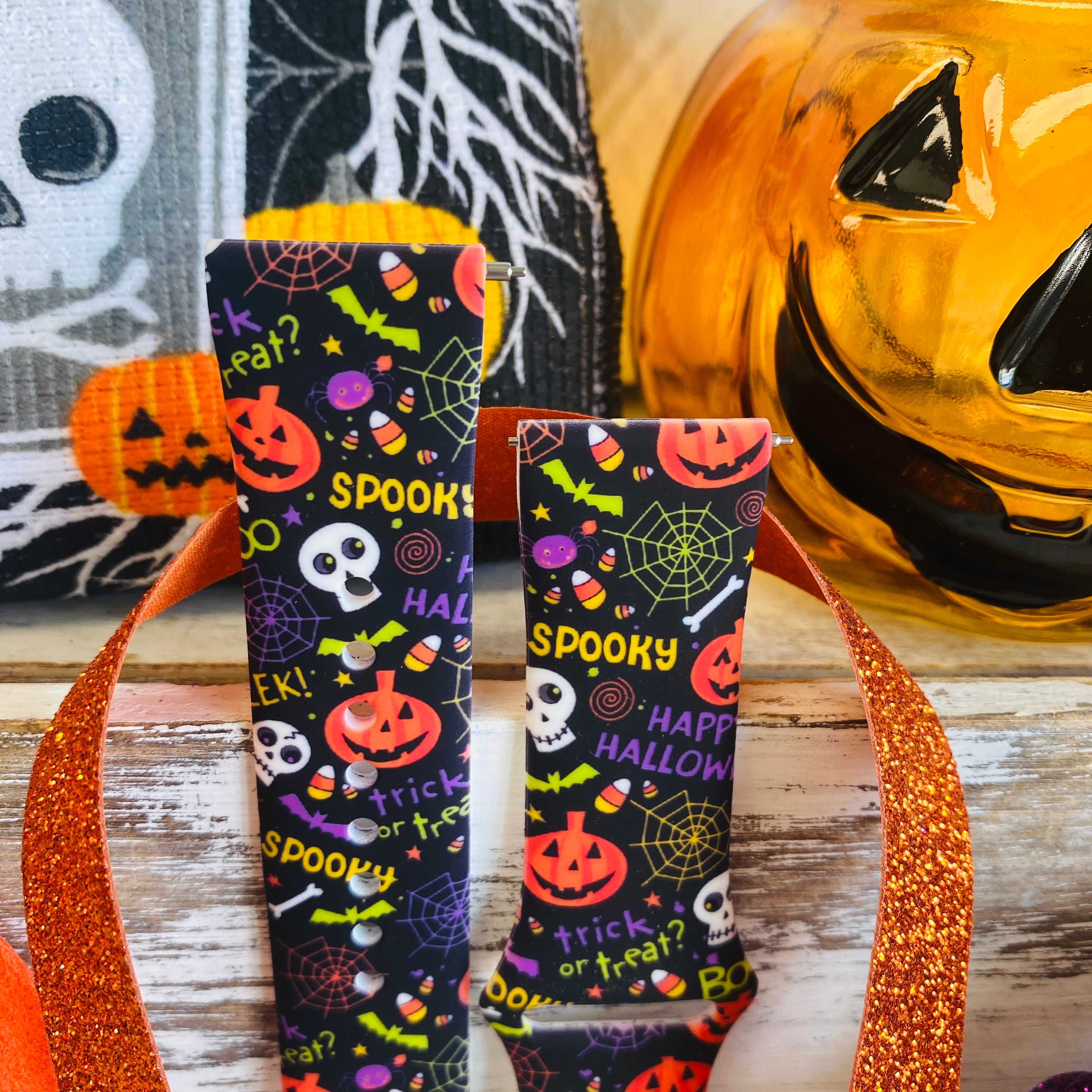 Both halves of the Spooky Samsung Galaxy Watch band standing upright, showing the SPOOKY lettering and candy corn print on black.