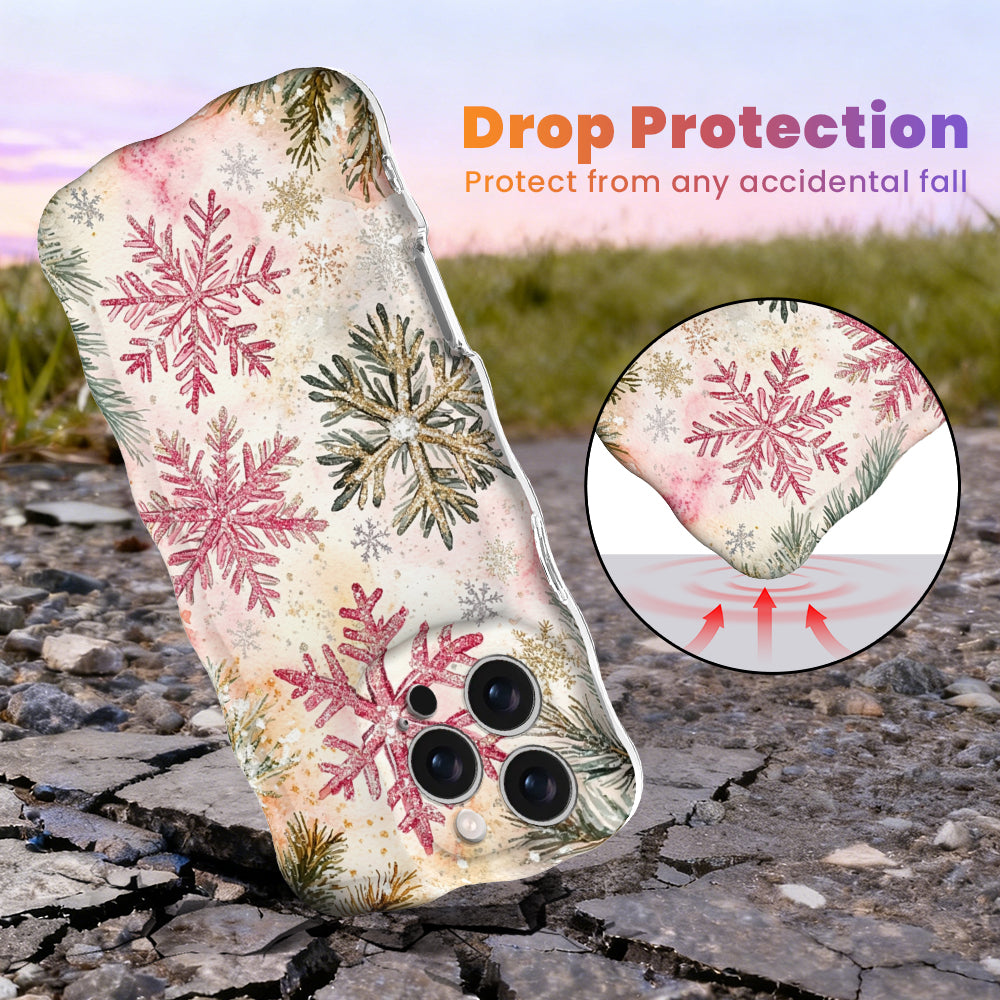 Champagne Snowfall Wavy Luxe MagSafe iPhone case, pink and gold glitter snowflakes on cream, standing on cracked pavement to show drop protection