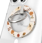 Fall Floral Bliss Hold It Fancy MagSafe grip ring close-up on a clear iPhone case, showing the cream base with watercolor rust mums, cream pumpkins, golden oak leaves, and acorns around the silver rotating ring.