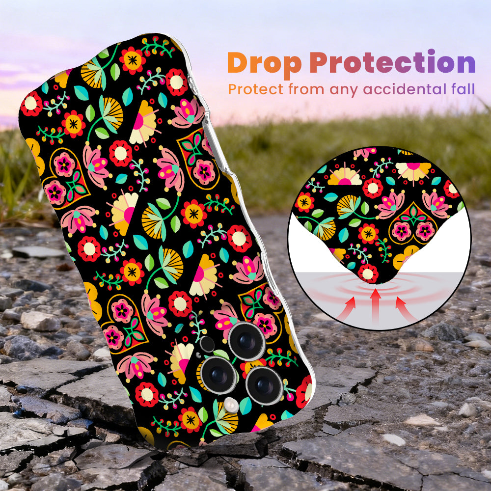 Trendy black wavy iPhone case featuring an intricate folk art botanical pattern of red flowers, magenta details, and yellow fan petals with a high-gloss finish.