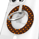 Spotted Looking Cute Hold It Fancy MagSafe grip ring close-up on a clear iPhone case, showing the chocolate brown ring with pumpkin-orange polka dots and the silver rotating metal ring.