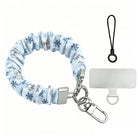 Snow Pretty In Blue scrunchie phone wrist strap laid flat with silver clasp and phone tab, silver bows and navy snowflakes on powder blue