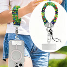 Petal Princess scrunchie phone wrist strap worn on the wrist with a MagSafe iPhone case, painted rainbow wildflower print from Fancy Bands